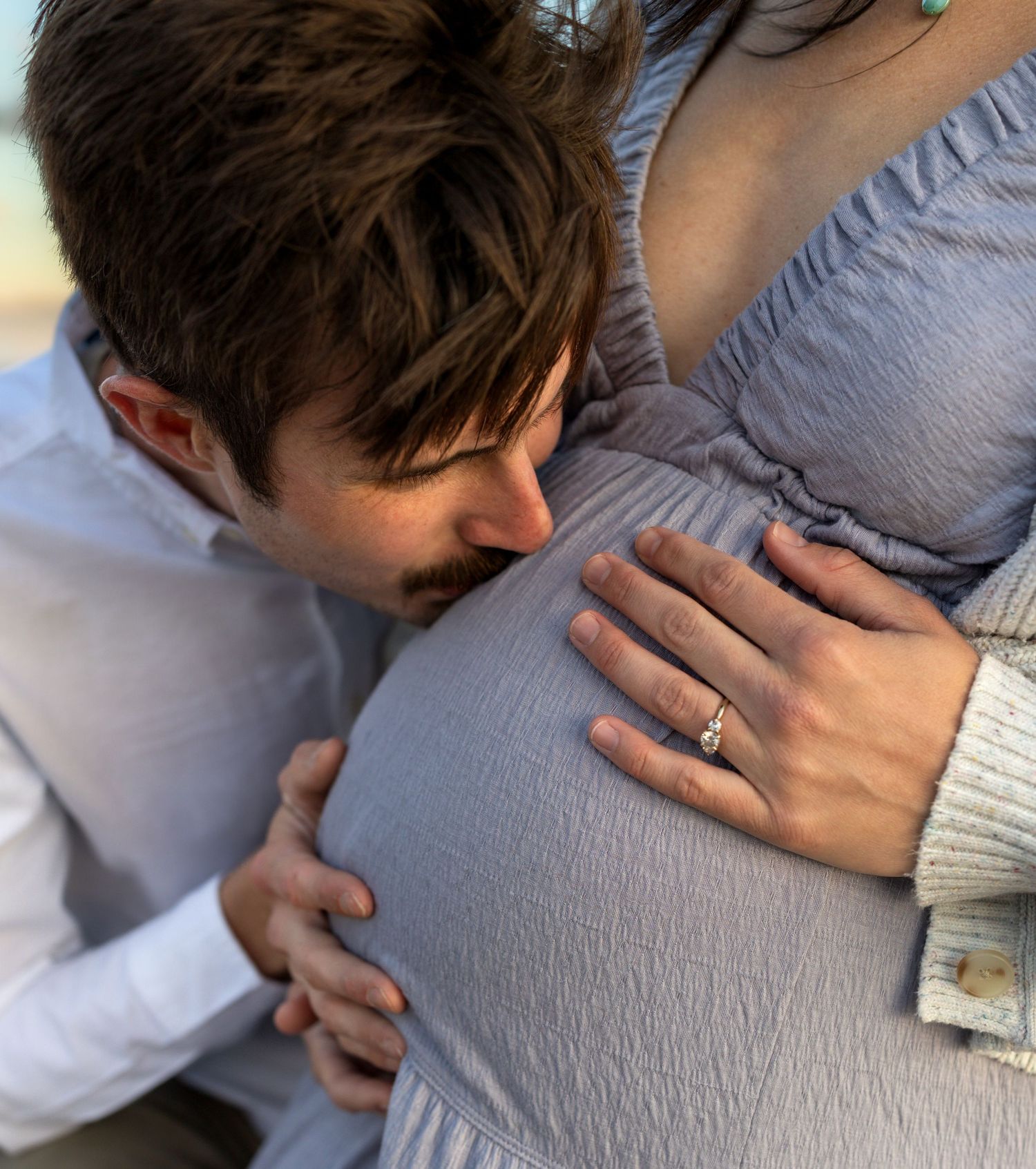 A man kisses his wife's pregnant belly