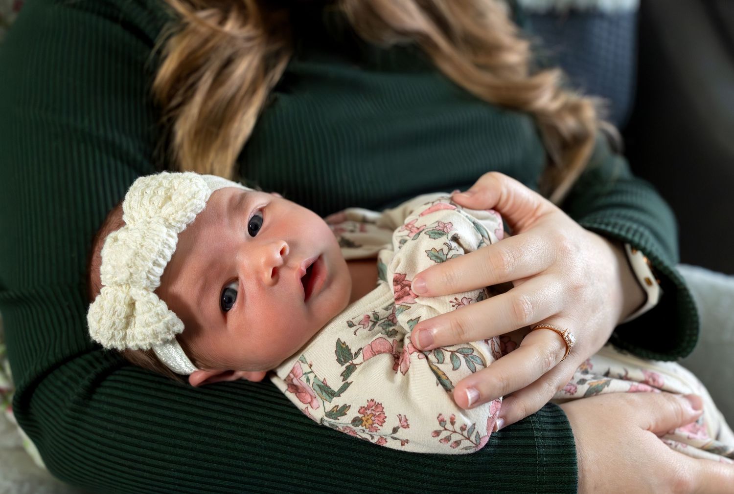 A newborn baby girl gazes into the camera.