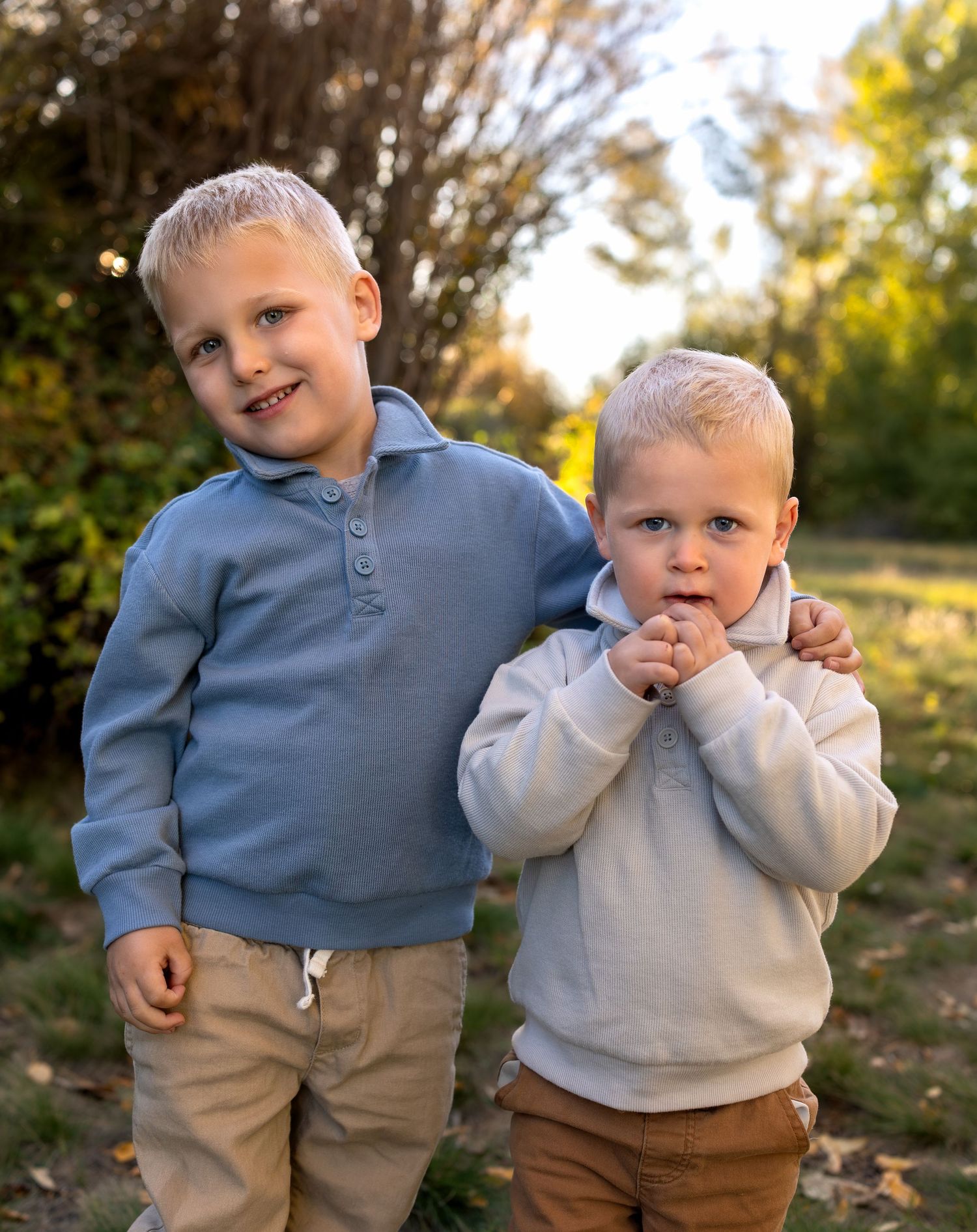 A photo of 2 young brothers in a green meadow
