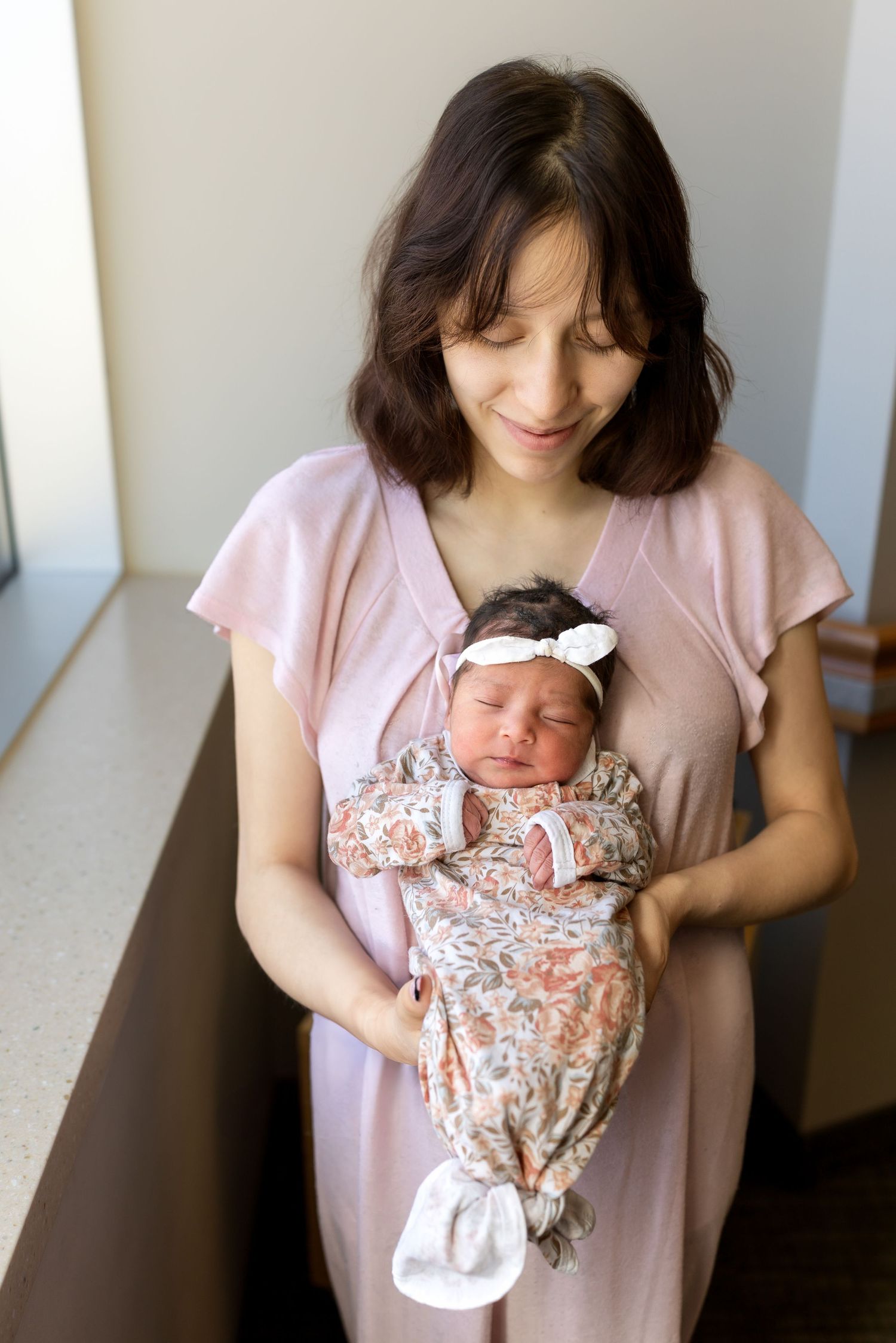 A new mother poses with her newborn daughter in the hospital