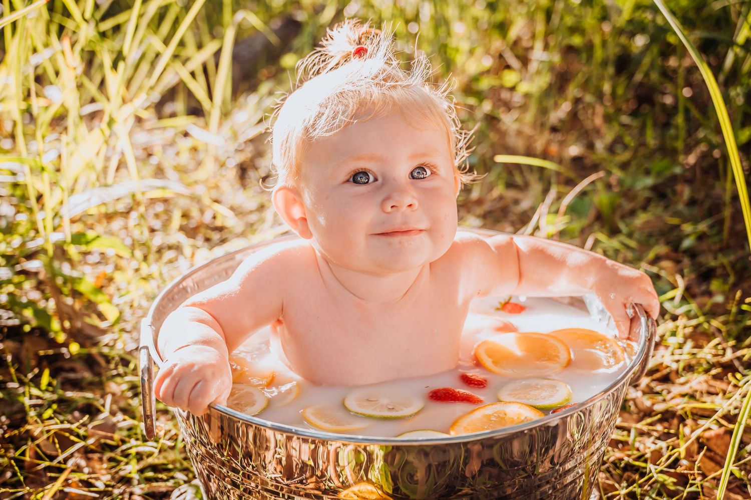 Sunlit milk bath photography with floating citrus and floral elements.