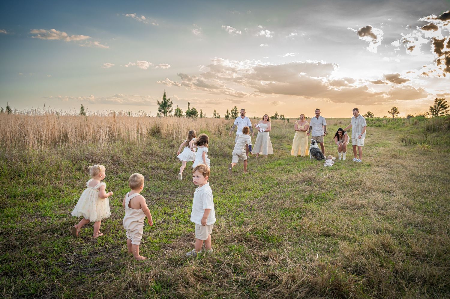 People in white clothes gathered in grassy field during golden hour.