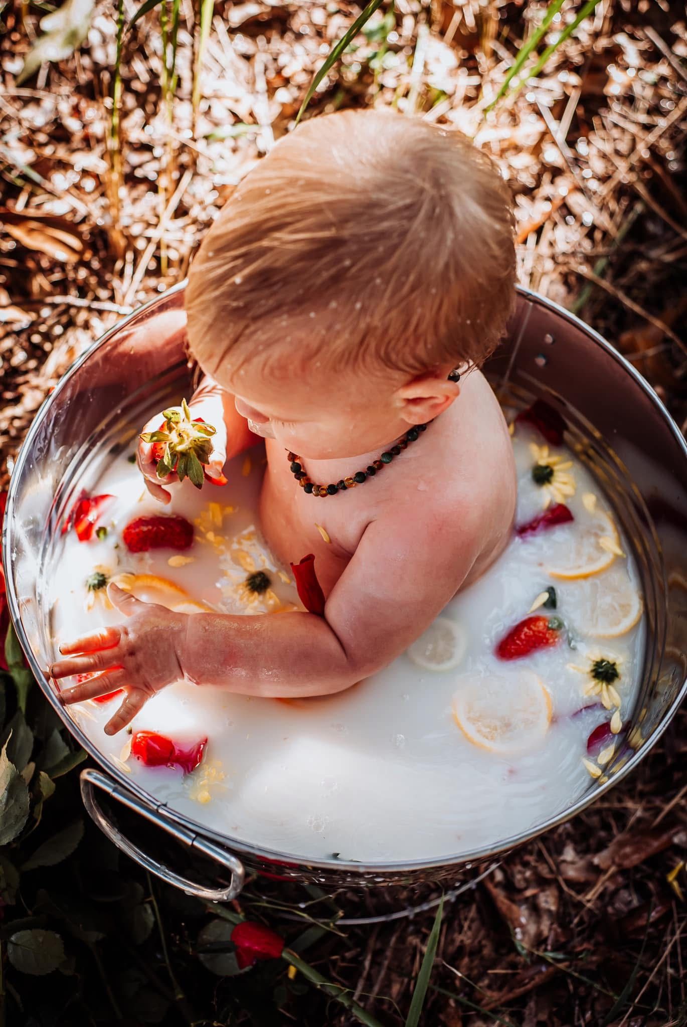 Artistic overhead shot of milk bath with floating citrus and flower elements.