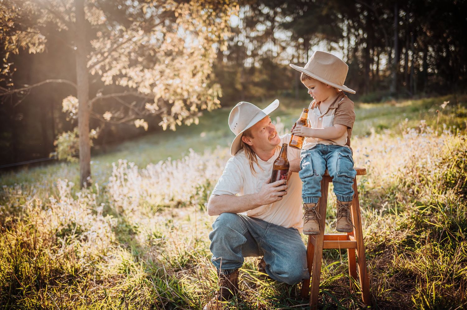 Sunlit outdoor family moment with rustic wooden ladder in a golden field.