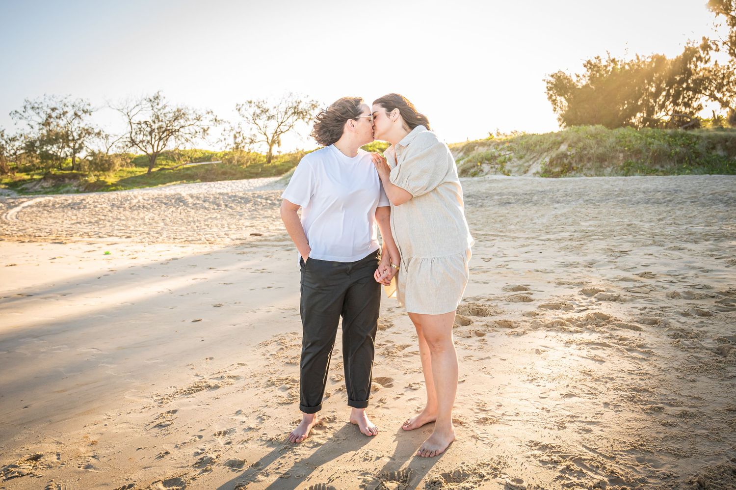 A tender beach moment captured during golden hour on sandy shores.
