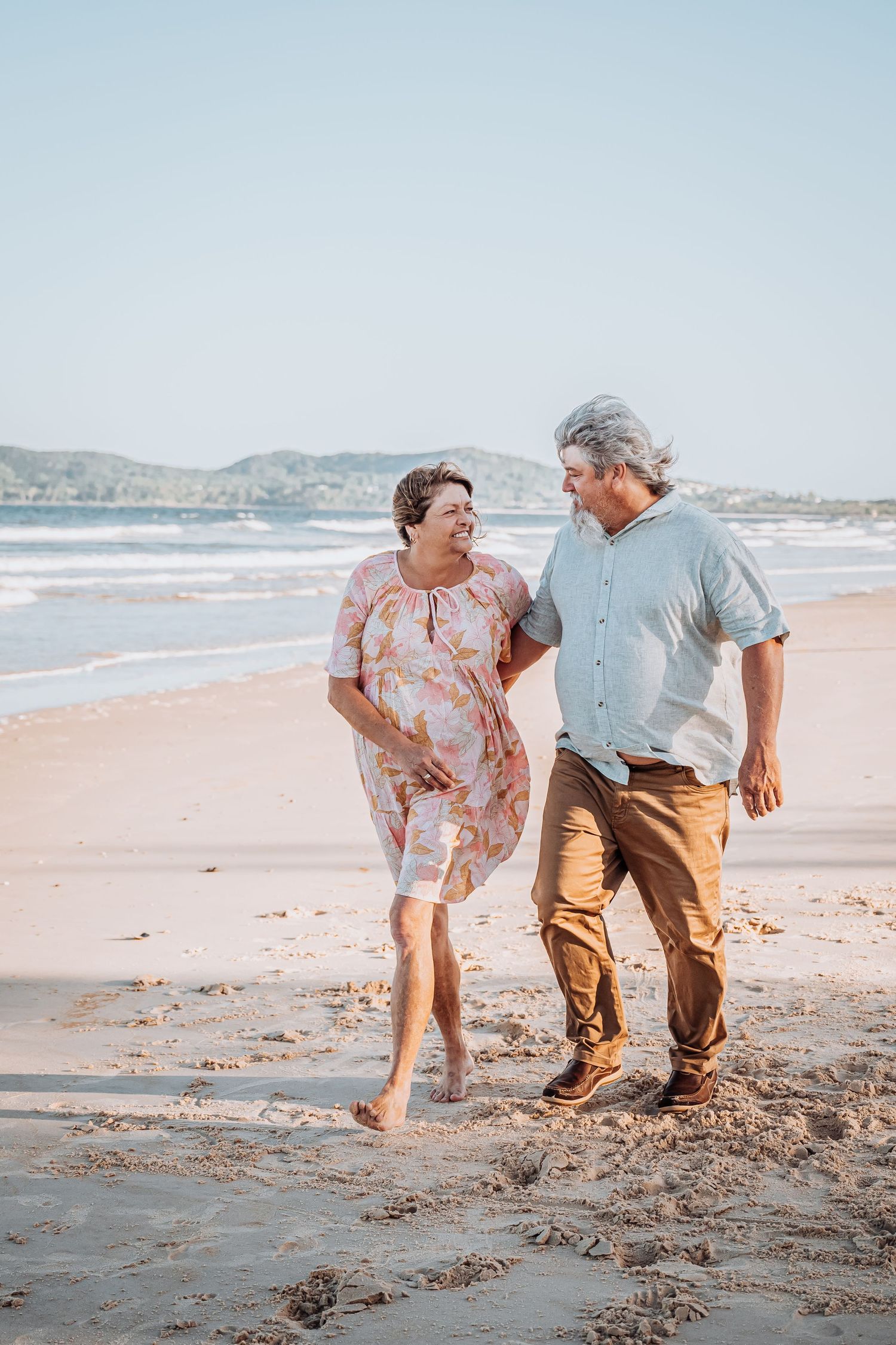 A cheerful stroll along the beach at sunset.