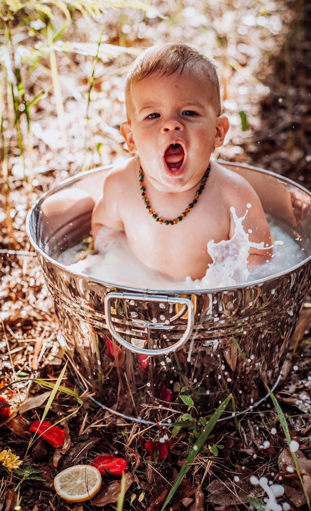 Joyful splash moment captured in decorative outdoor milk bath setting.