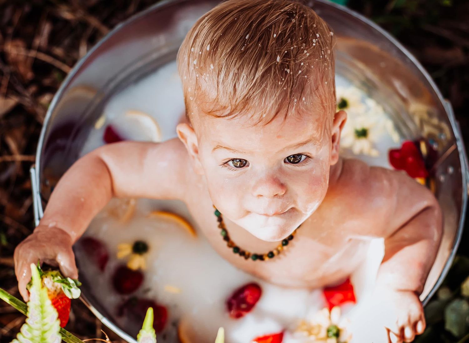 Creative milk bath photography featuring citrus slices and floral decorations.