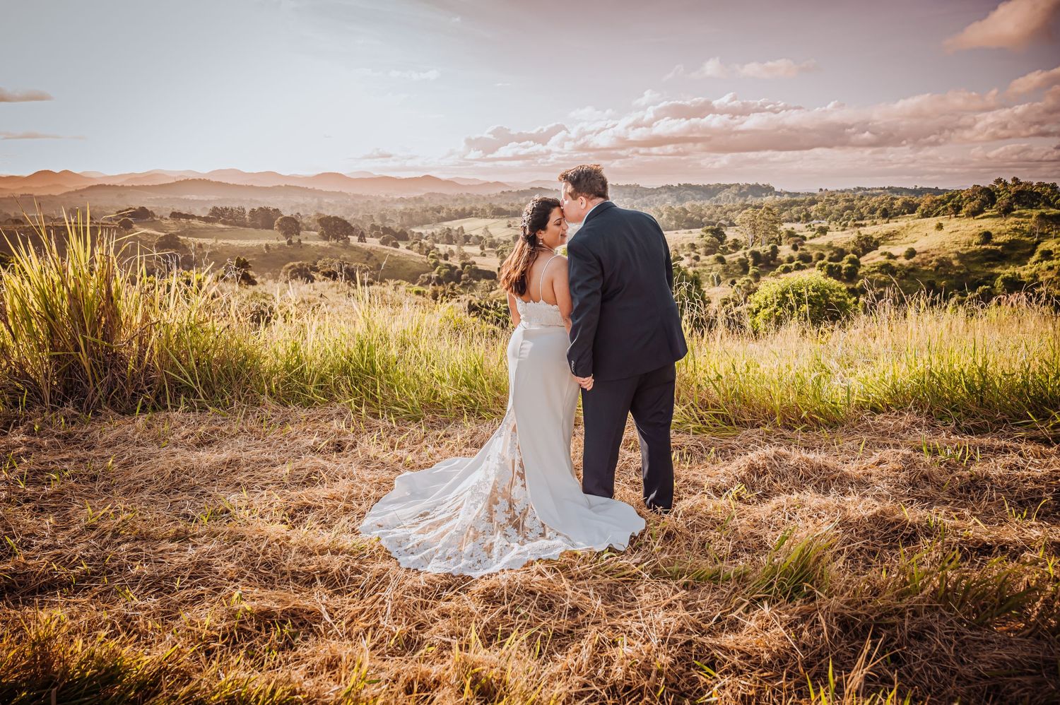 Sunset wedding portrait with rolling hills and golden landscape in rural countryside setting.
