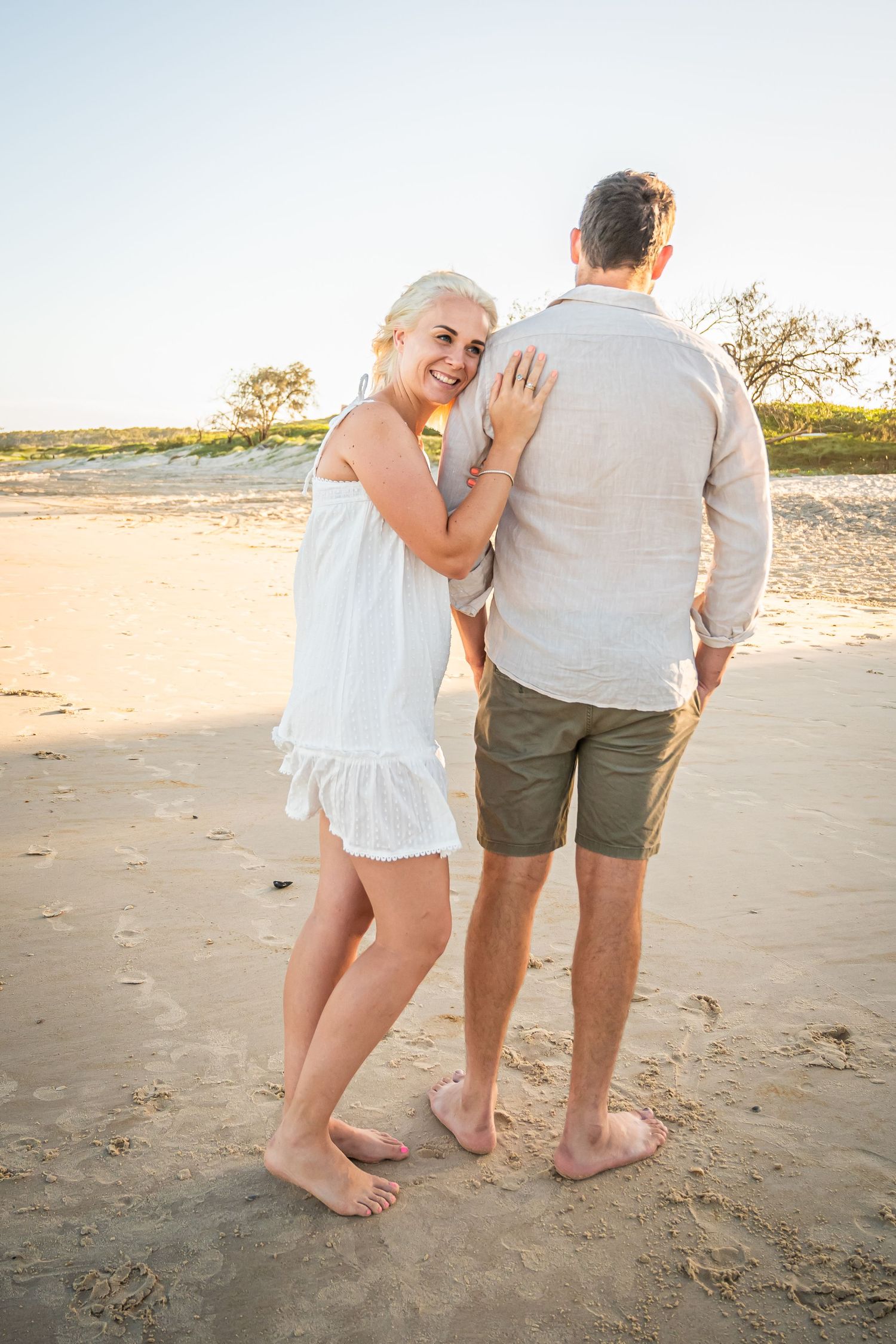 A sweet candid moment shared between two people on a sunny beach.