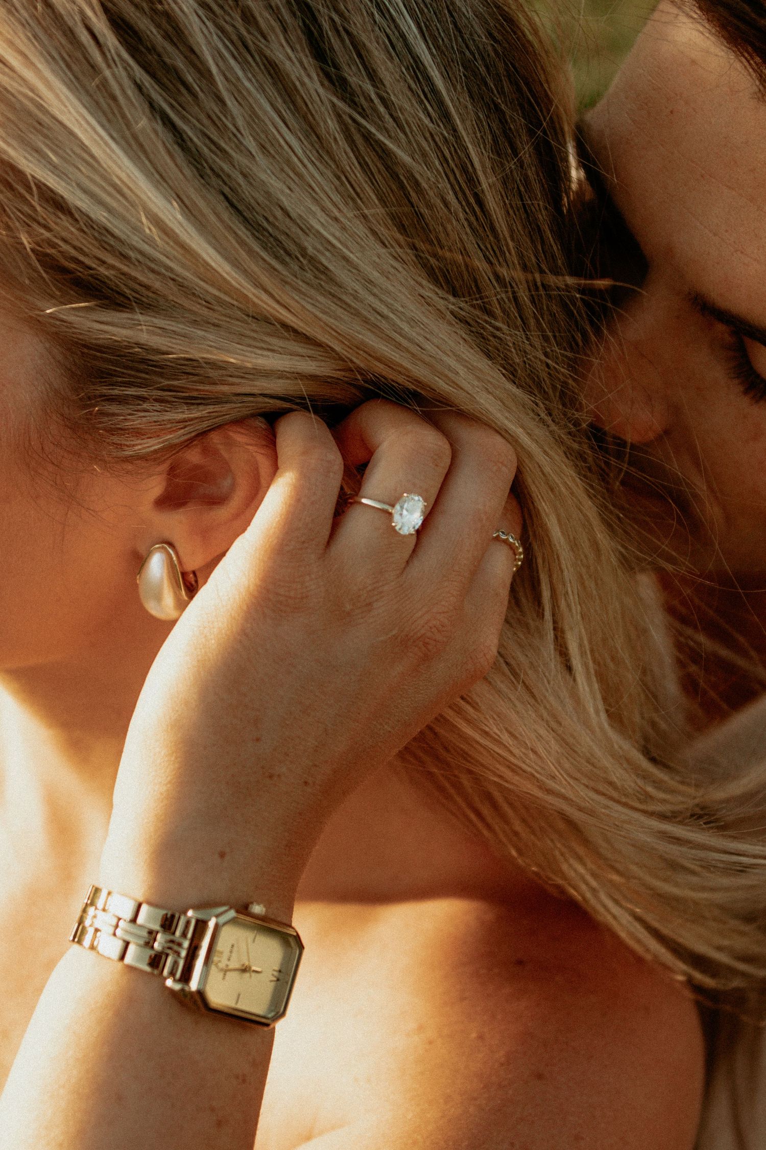 engagement ring, girls hand running through hair, focus on engagement ring