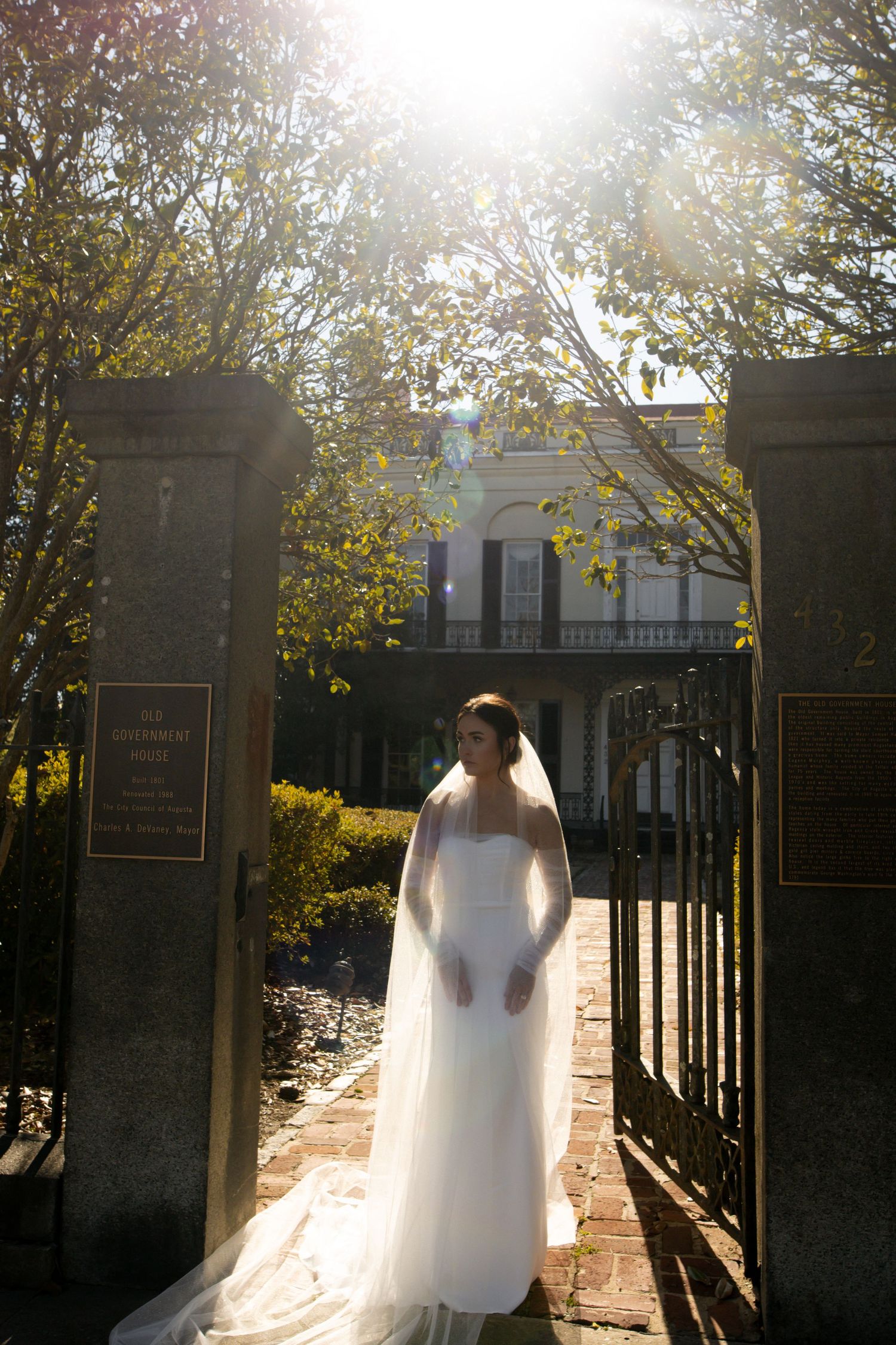 bride, looking to the side, standing in front of big building