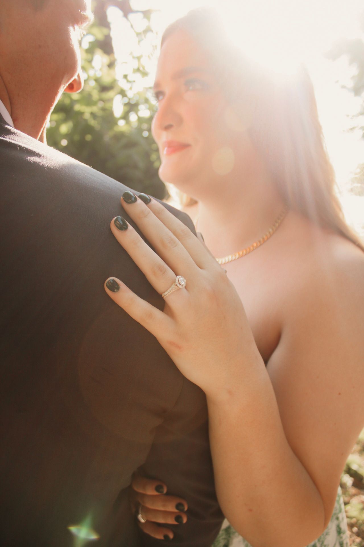 engagement ring, girls hand on boys shoulder, smiling at each other, focus on ring