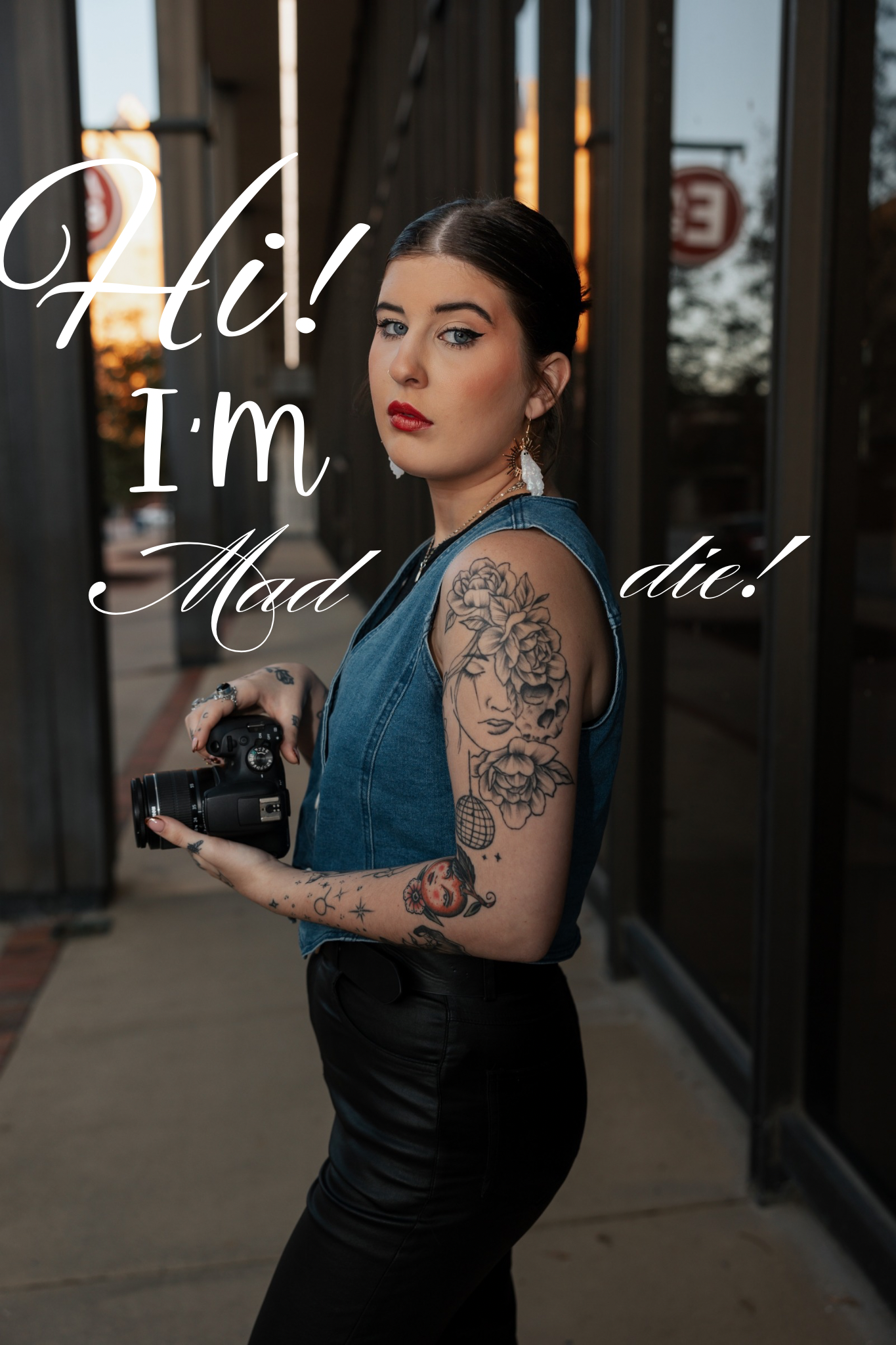 photographer, looking at camera, girl holding camera, tattoos, straight face, says 