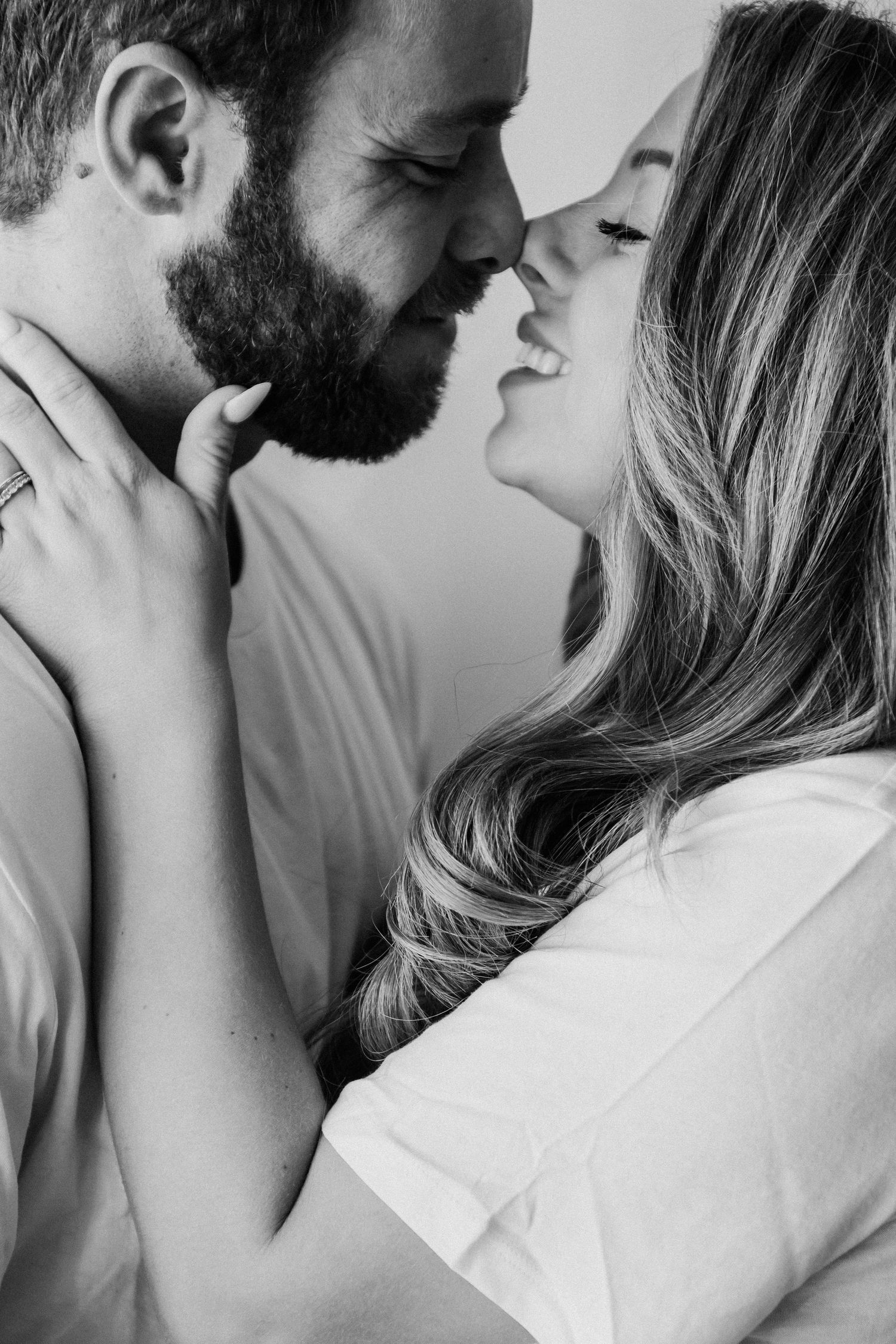 black and white, couple, boy and girl, almost kissing, smiling at each other, girls hand on boys face