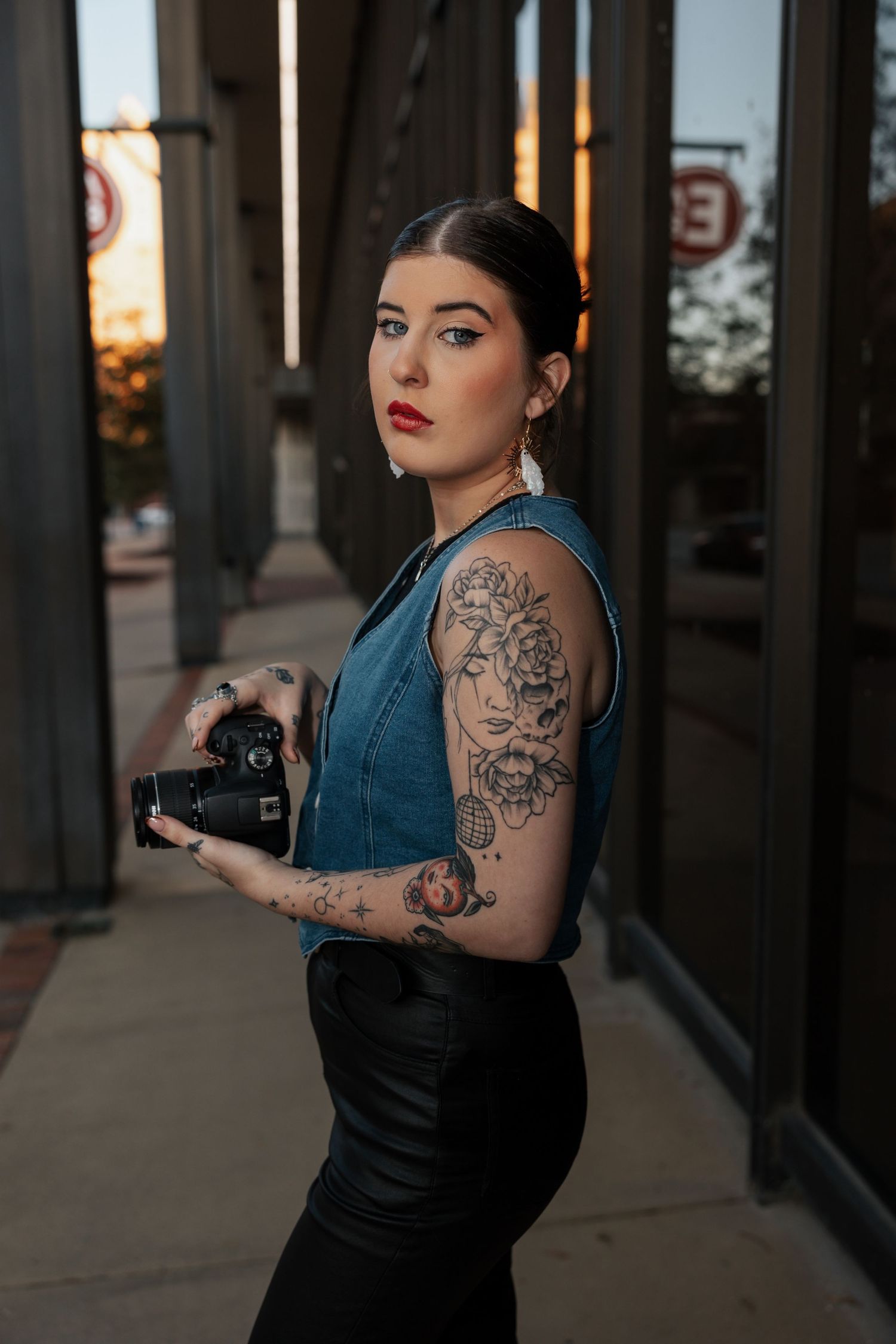 photographer, looking at camera, girl holding camera, tattoos, straight face