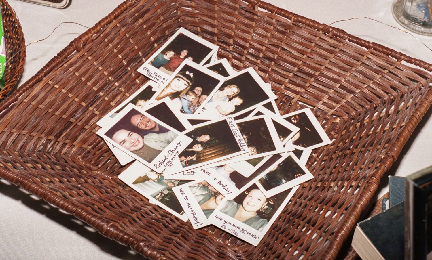 Editorial flash film style photo of a dish of polaroids at a wedding