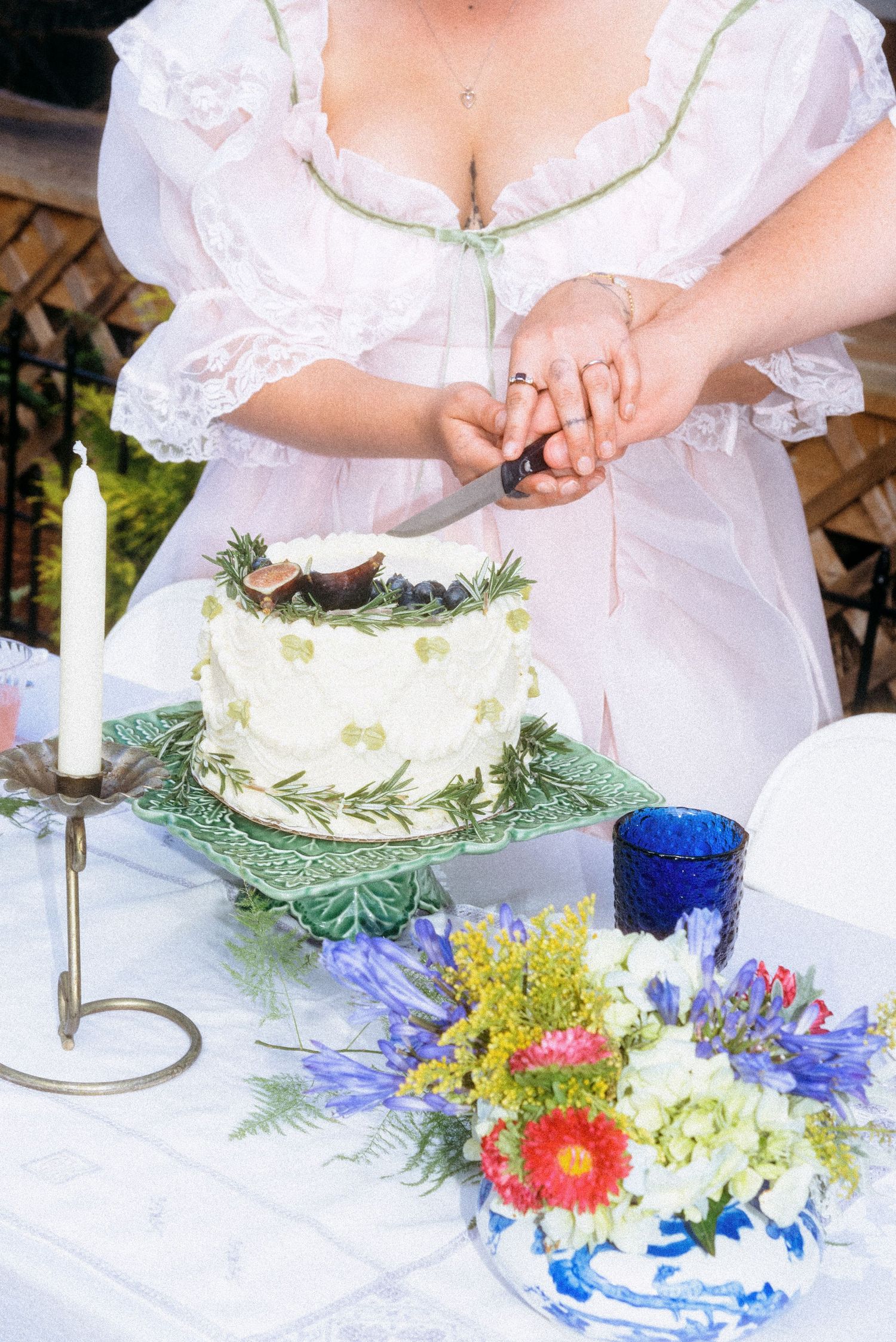 Editorial high contrast film style close up photo of a bride and groom cutting their wedding cake