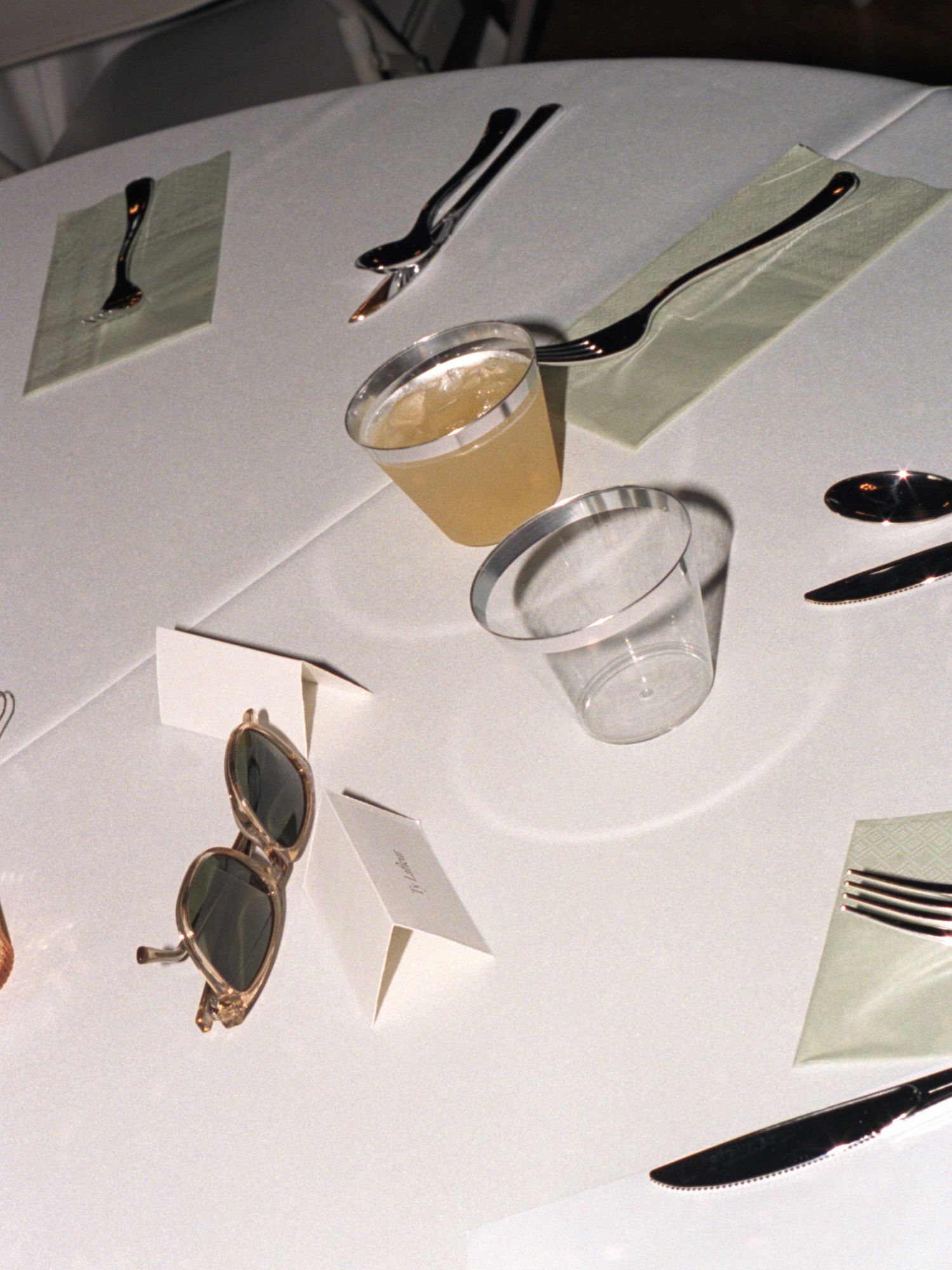 Editorial flash film style wedding photography of glasses and forks on a wedding reception table