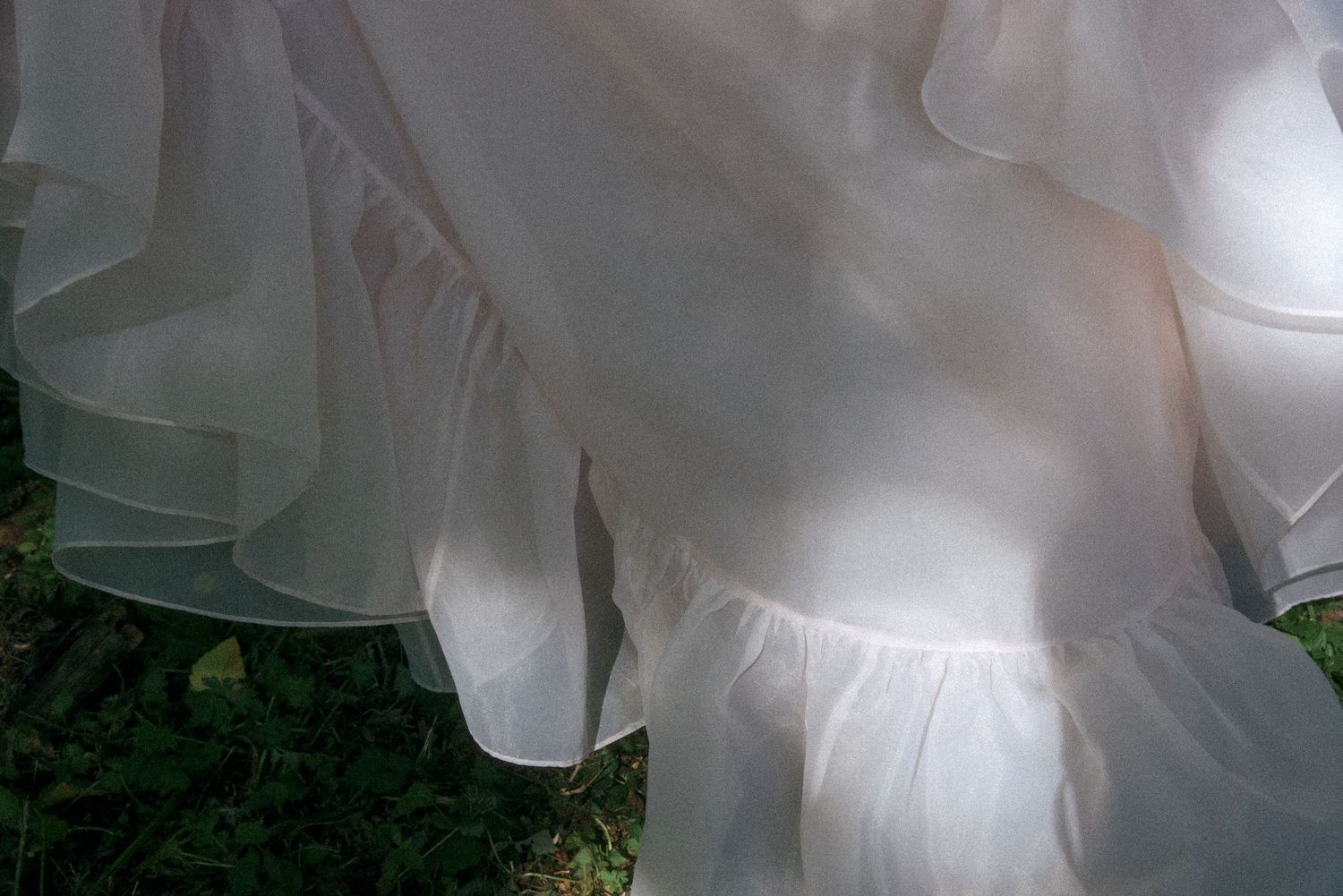 Abstract film style photo of the bottom of a bride's dress