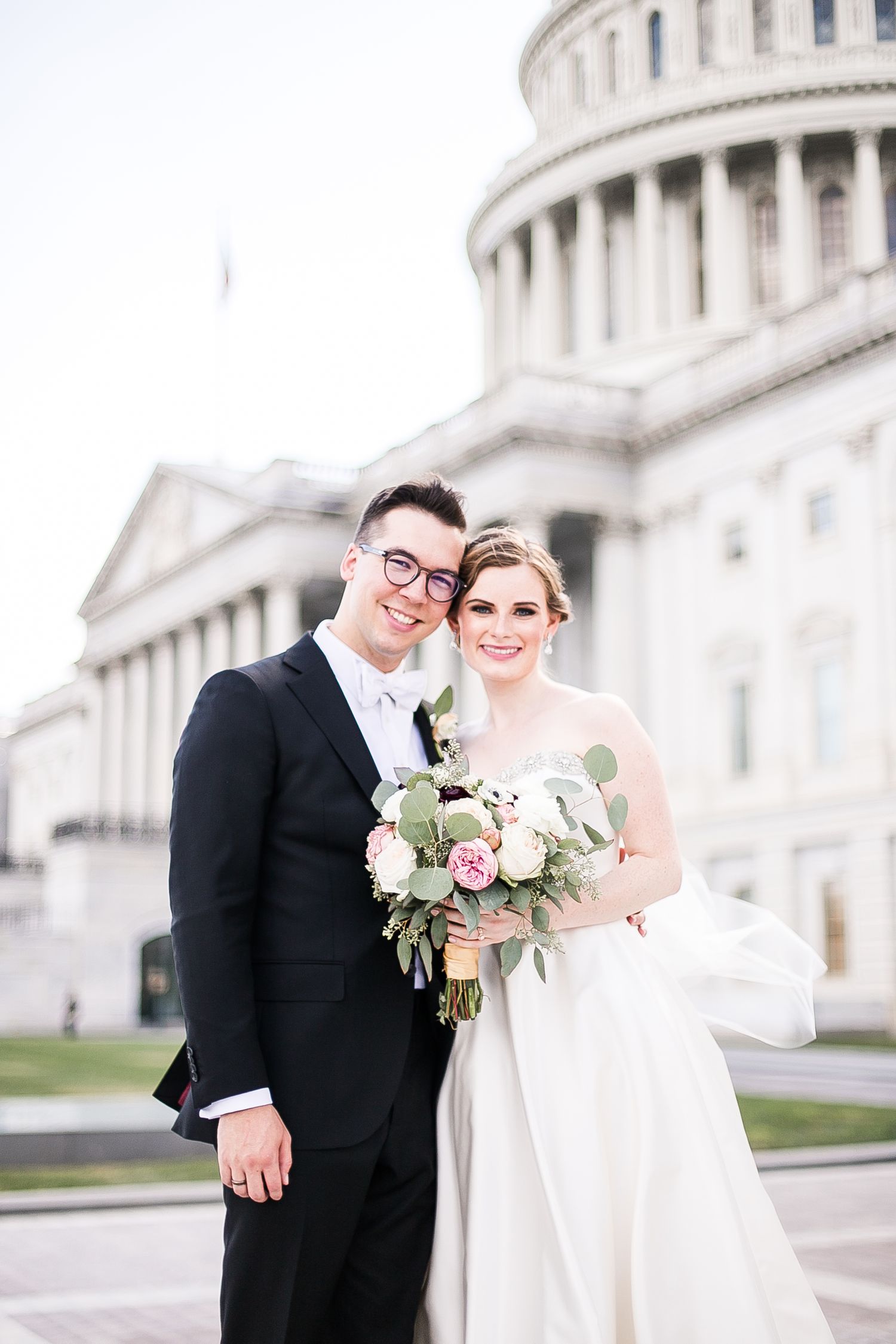 A wedding couple poses in formal attire outside the U.S. Capitol Building in Washington DC.