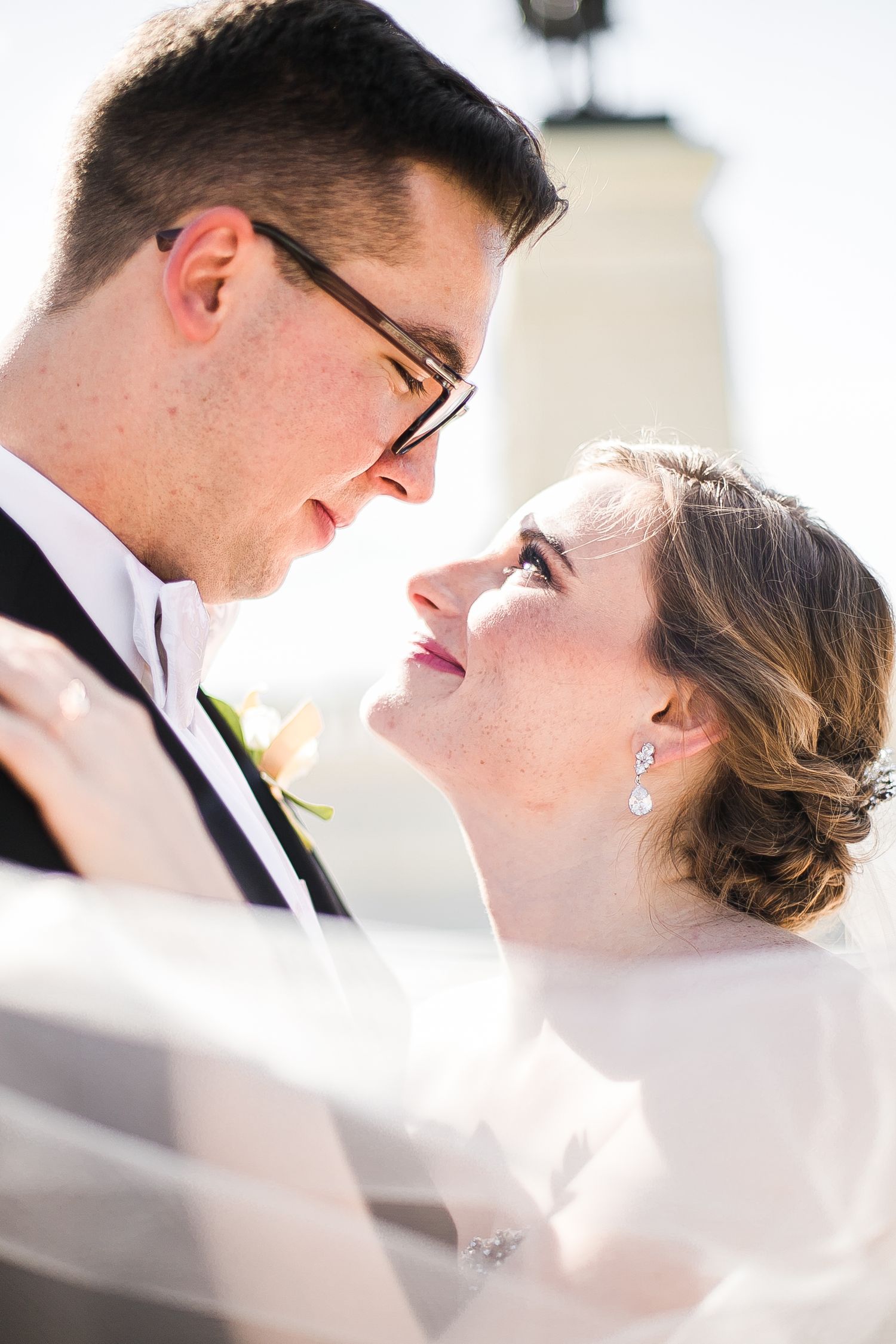 Close up artistic collage of bride and groom sharing intimate moments under a white veil at their wedding.