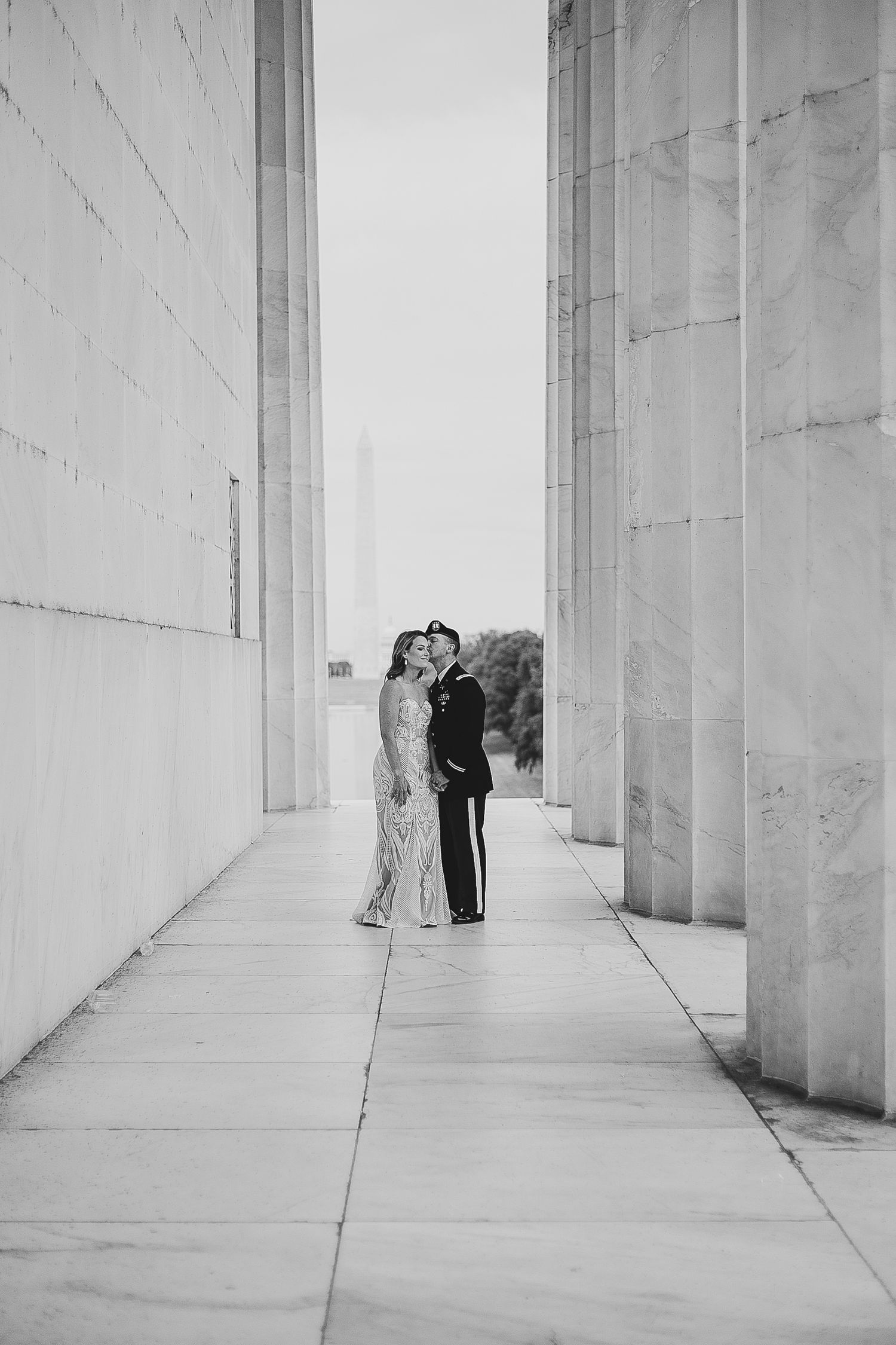 A set of four black and white photographs showing two people embracing in a minimalist hallway with white walls.
