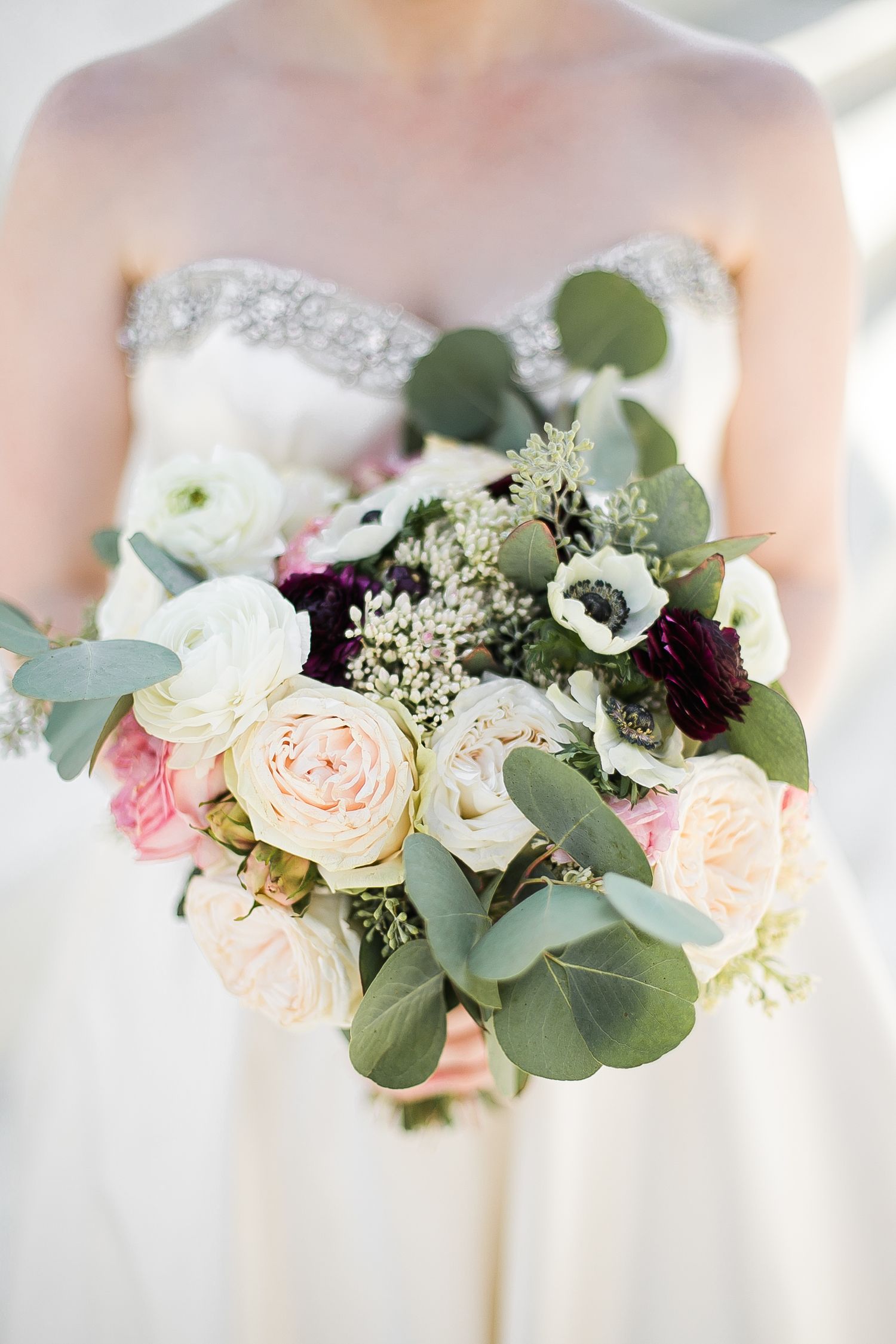 Beautiful wedding bouquets with blush roses, white anemones, and silvery eucalyptus leaves displayed in a row.