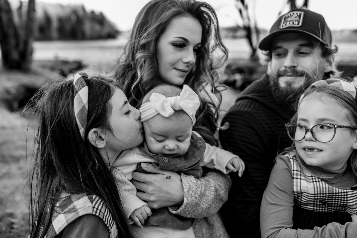 Black and white portrait of a family group gathered close together outdoors.