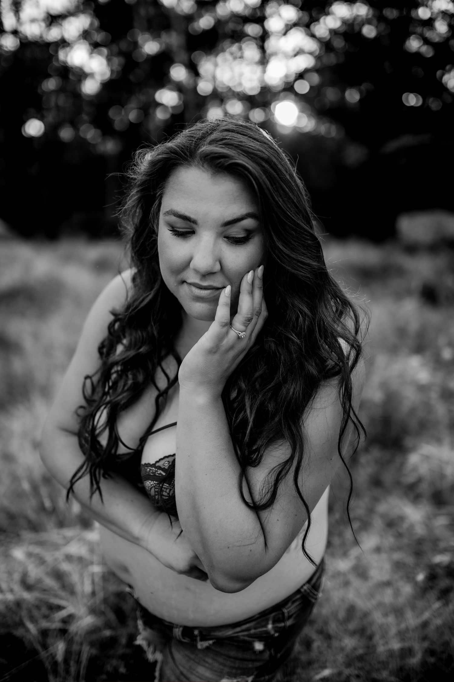 Intimate black and white portrait capturing soft contemplative moment in nature.