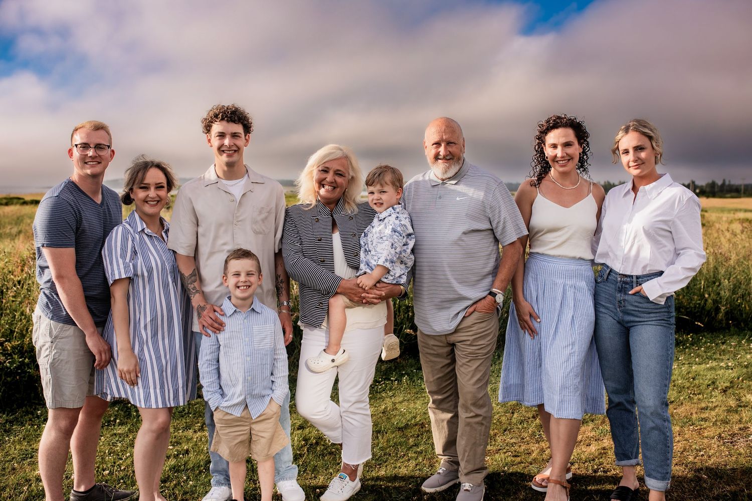 Extended family gathering outdoors for a group photo on a beautiful summer day.