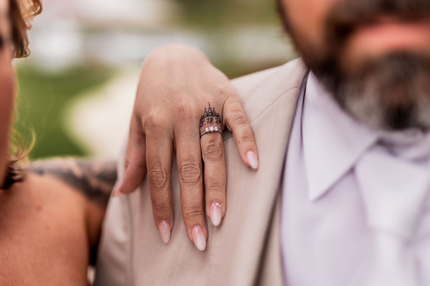 Close-up of an engagement ring on a bride's manicured hand.
