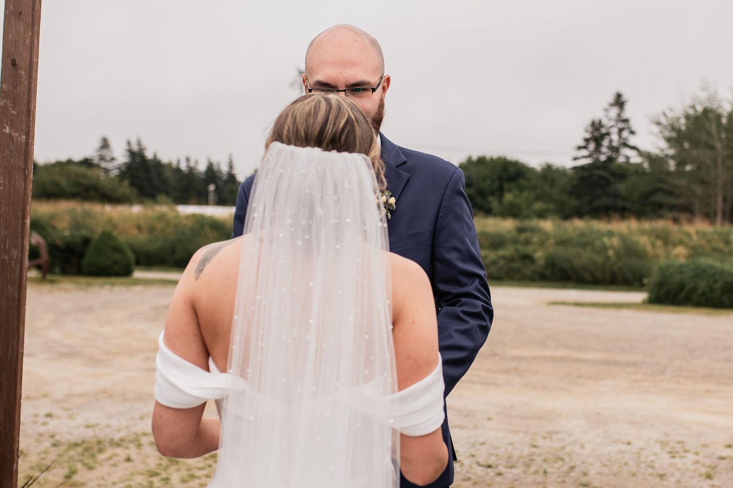 Romantic outdoor wedding portraits captured in a rustic field setting.