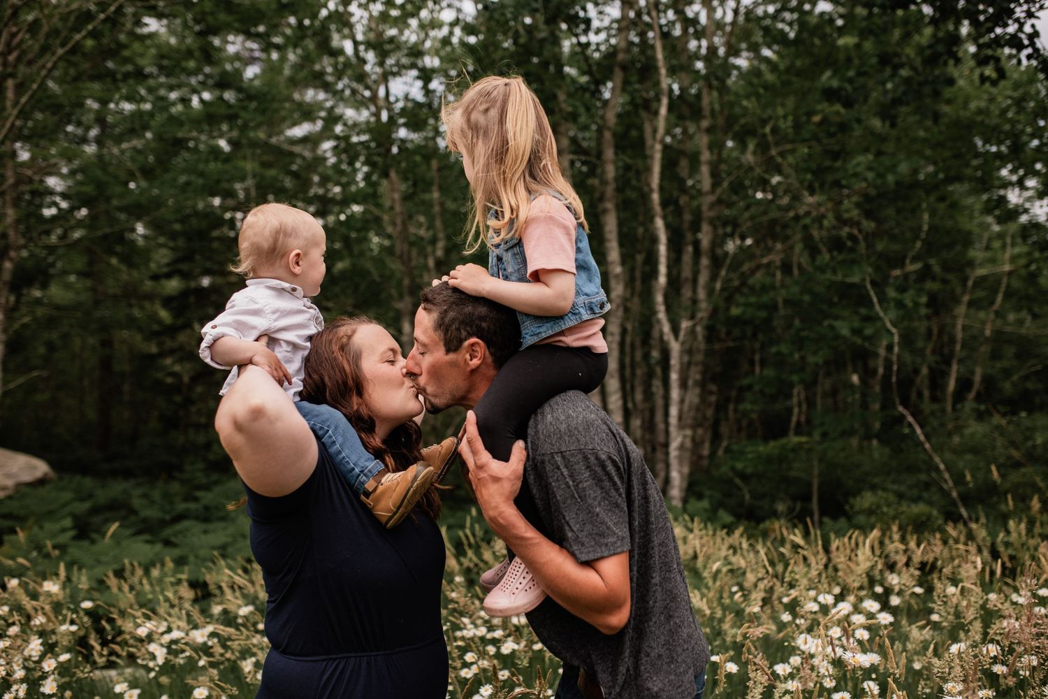 Family enjoying outdoor moment together among blooming daisies.