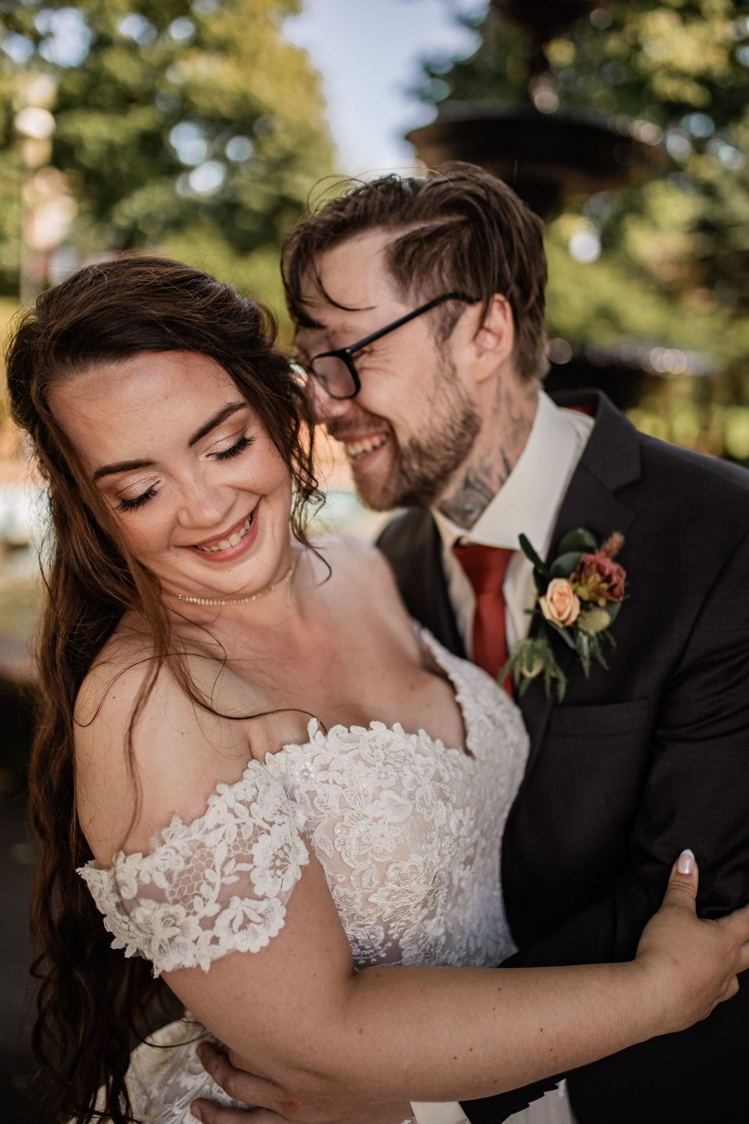 Intimate wedding portrait of couple in warm natural lighting outdoors.