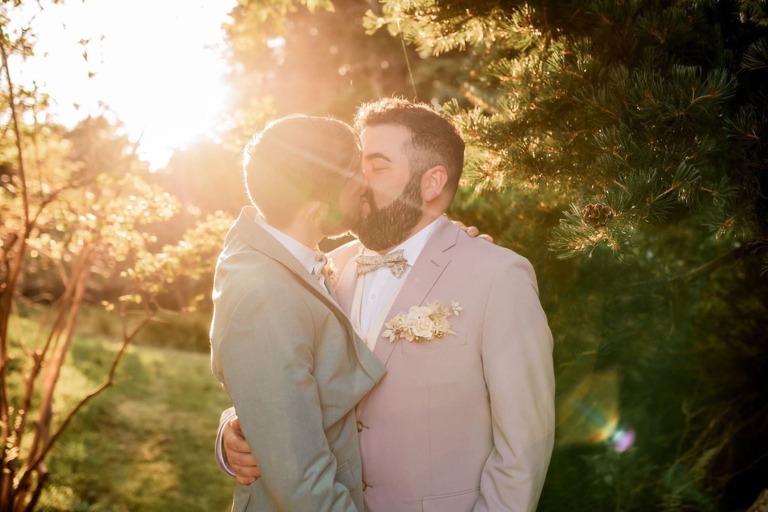 Couple shares intimate moment in warm sunset lighting during wedding celebration.