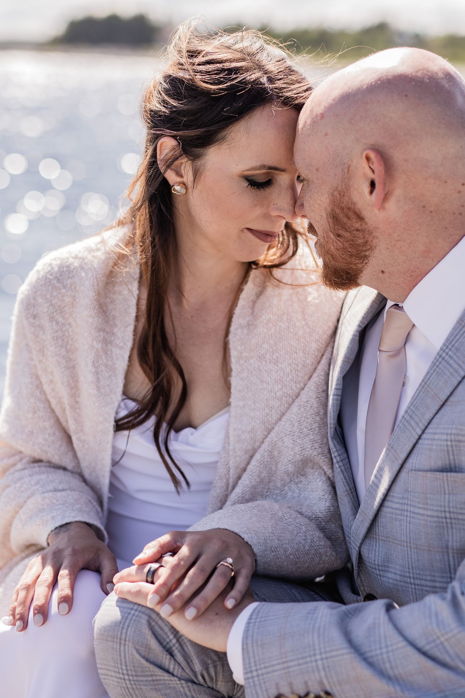 Intimate romantic couple embracing in casual winter attire during an outdoor photoshoot.