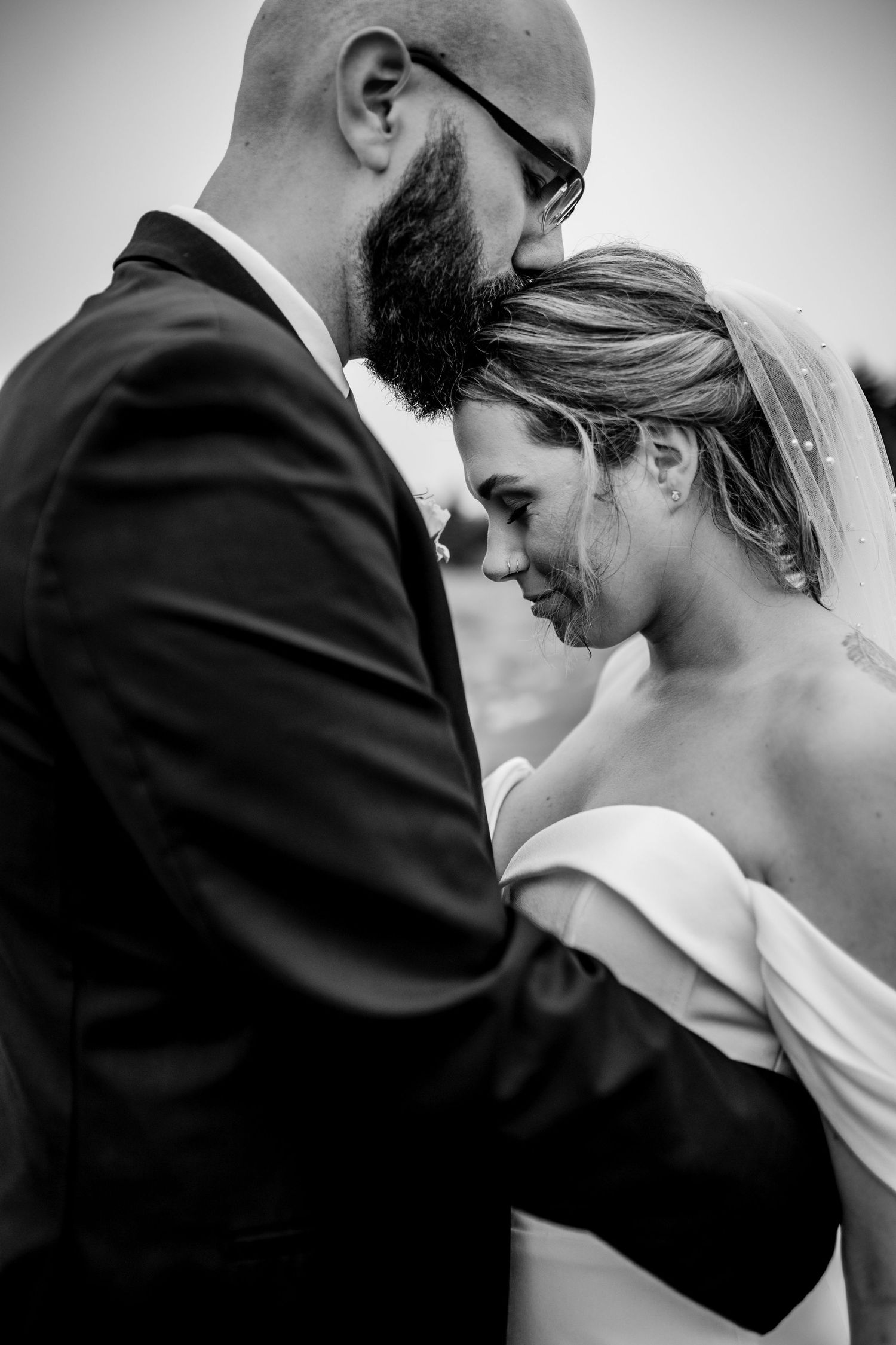 Black and white portrait of newlyweds in intimate embrace showing emotional connection.