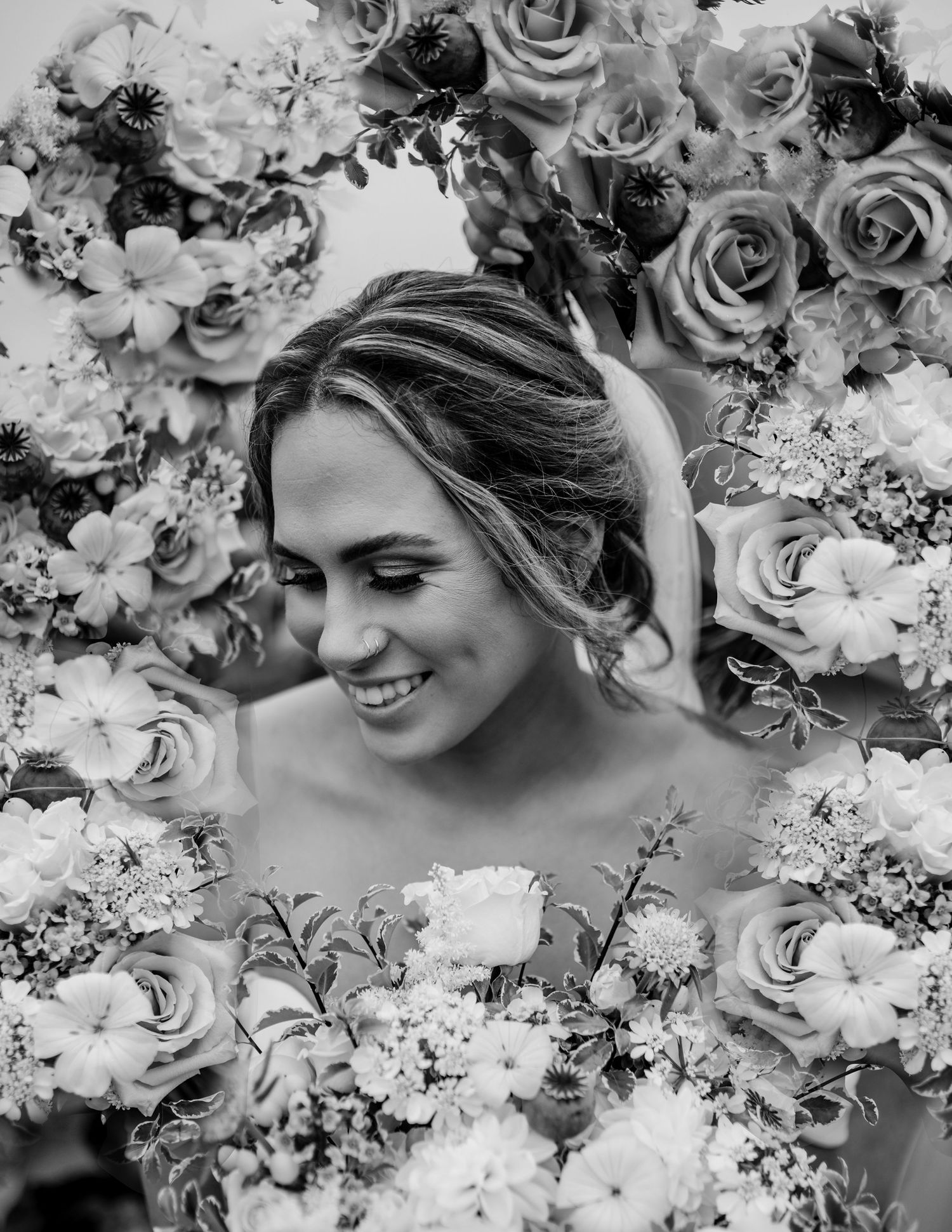 Black and white artistic bridal portrait framed by romantic roses.