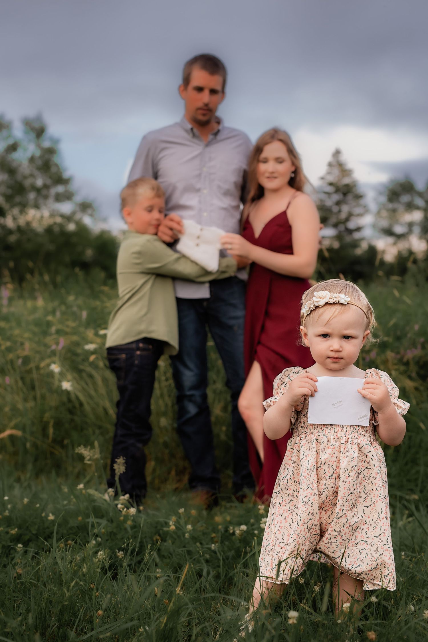 Intimate family portrait session in a summer field with golden light.