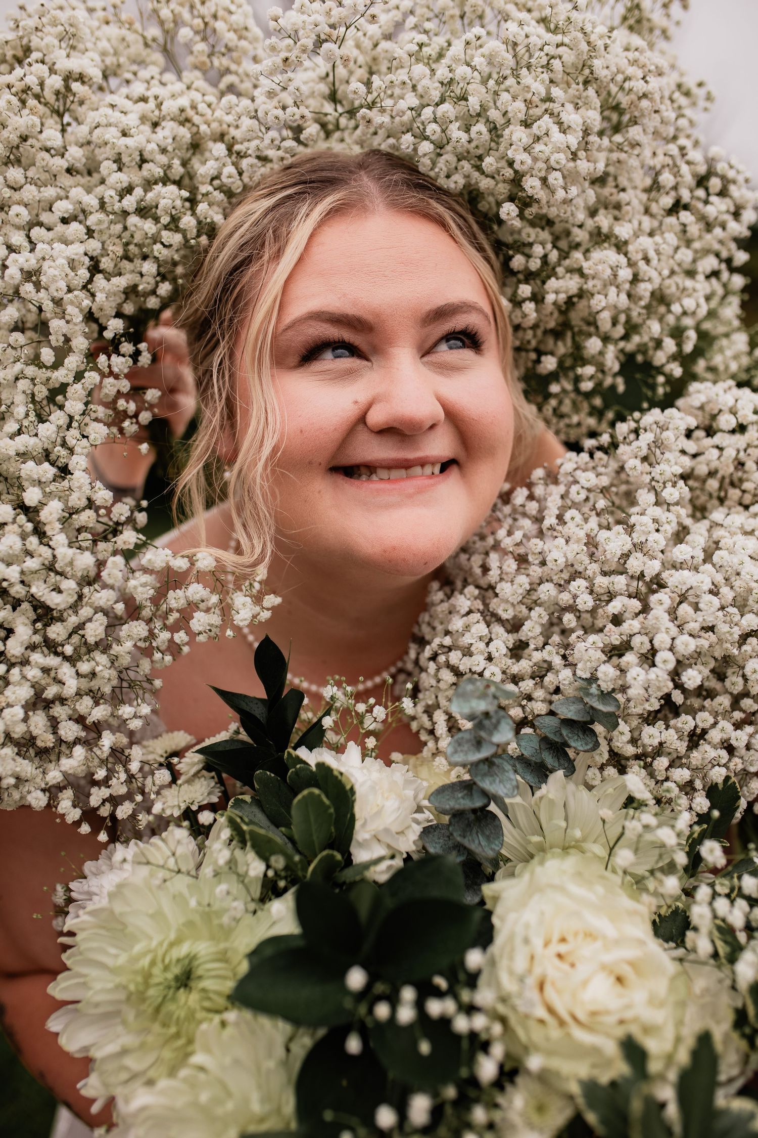 A bridal portrait surrounded by baby's breath flowers and white roses.