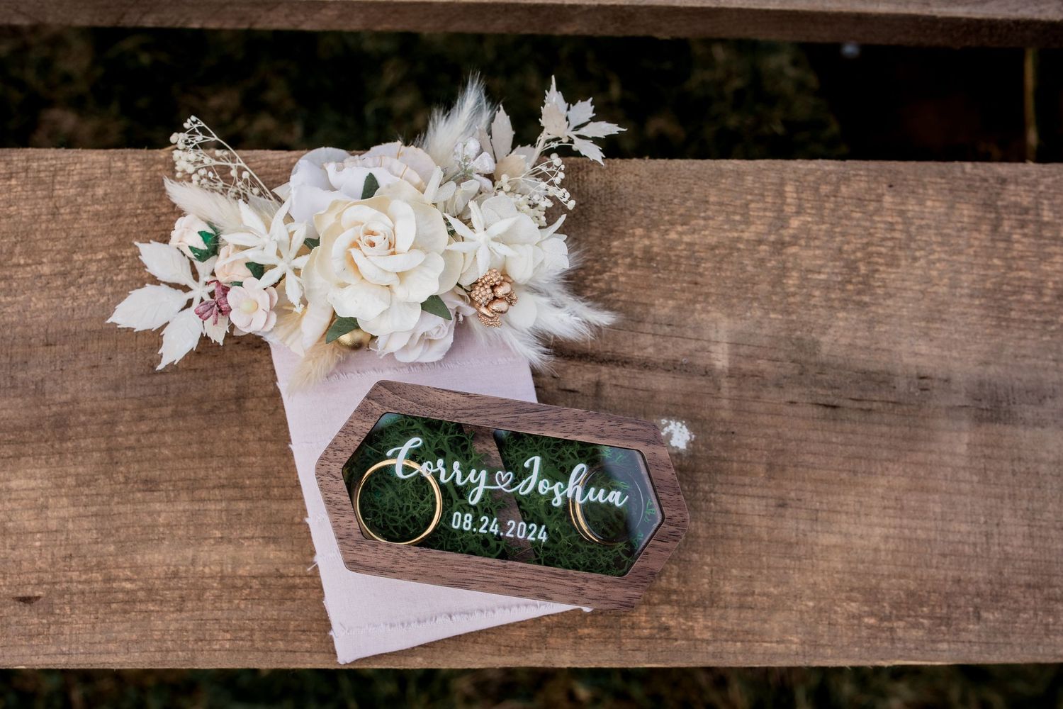 White floral arrangement with decorative name tag on rustic wooden surface.