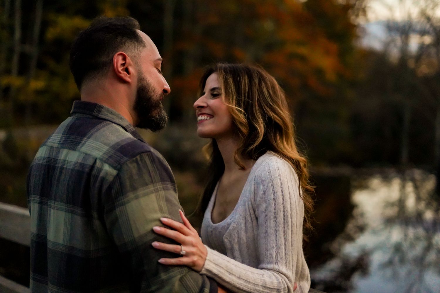 Intimate moment captured during sunset with autumn forest backdrop.