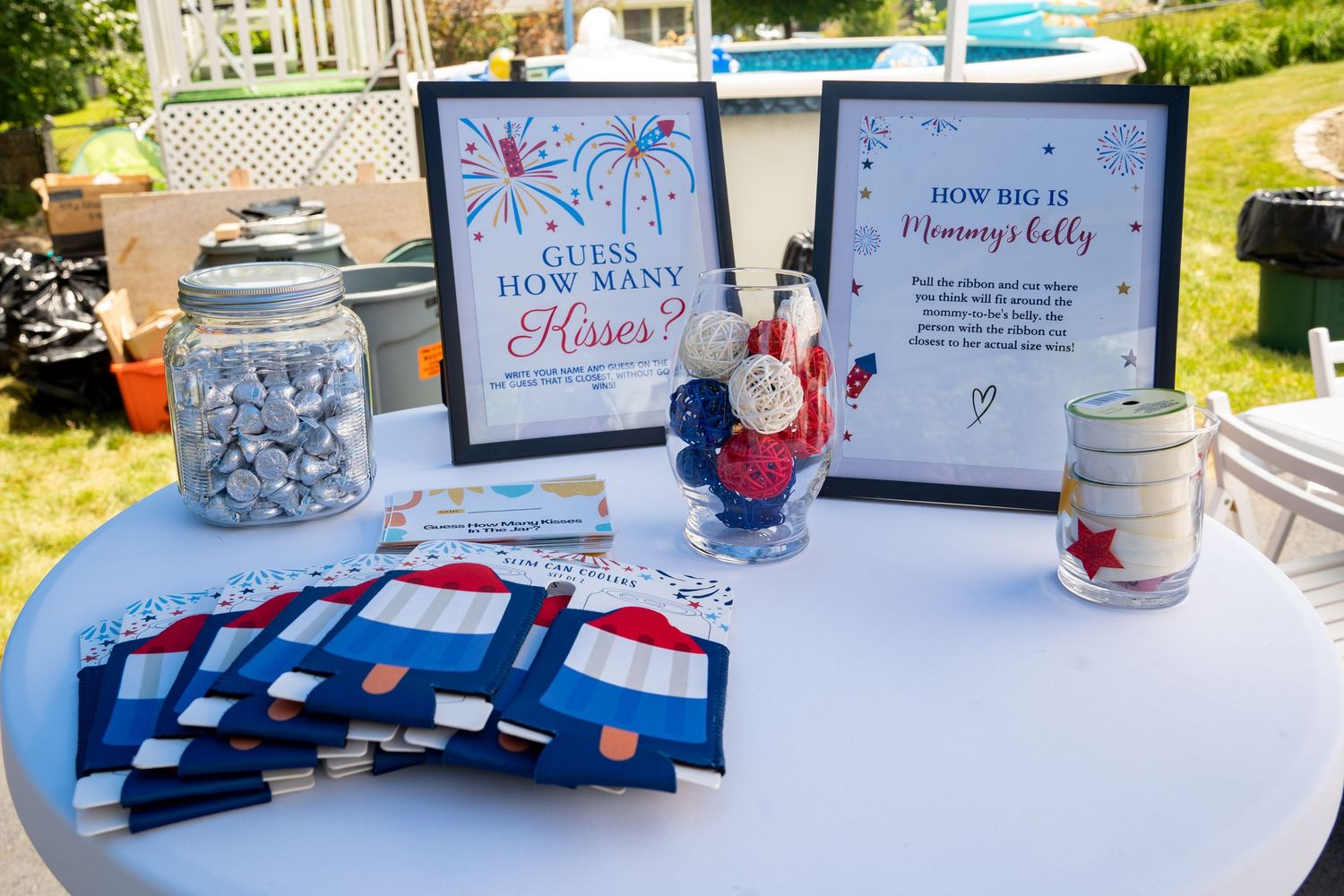 Patriotic themed party table with red white and blue decorations and signs about baby shower games.