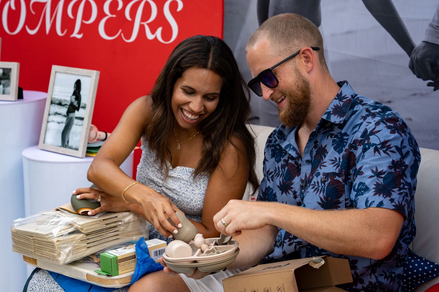 A couple opening gifts at an outdoor baby shower.
