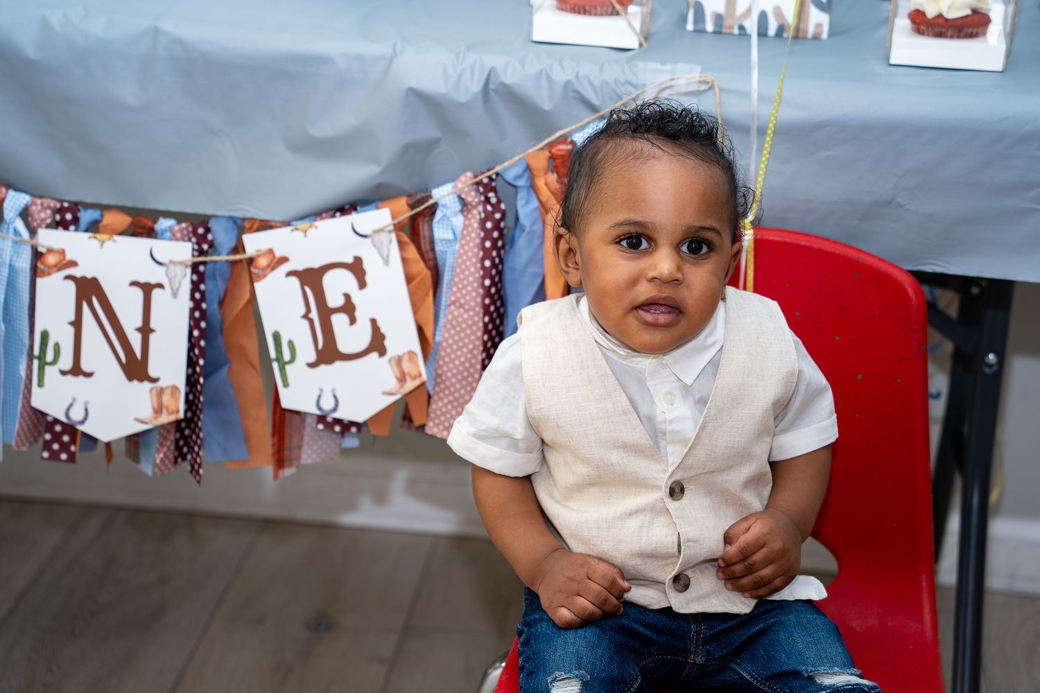 The birthday boy sitting in front of a sign that says 