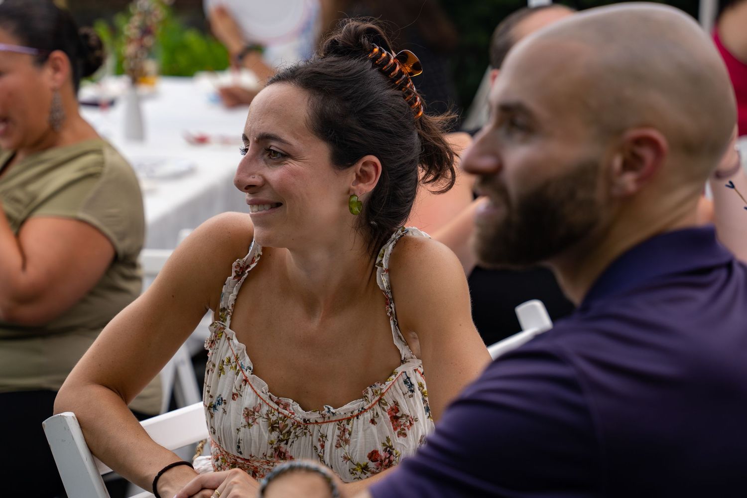 A couple sharing a joyful moment while seated at a reception dinner table.