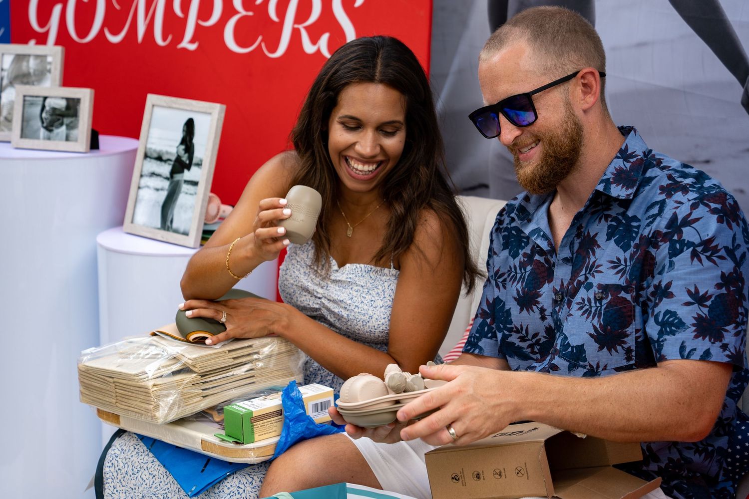 A couple opening gifts at an outdoor baby shower.