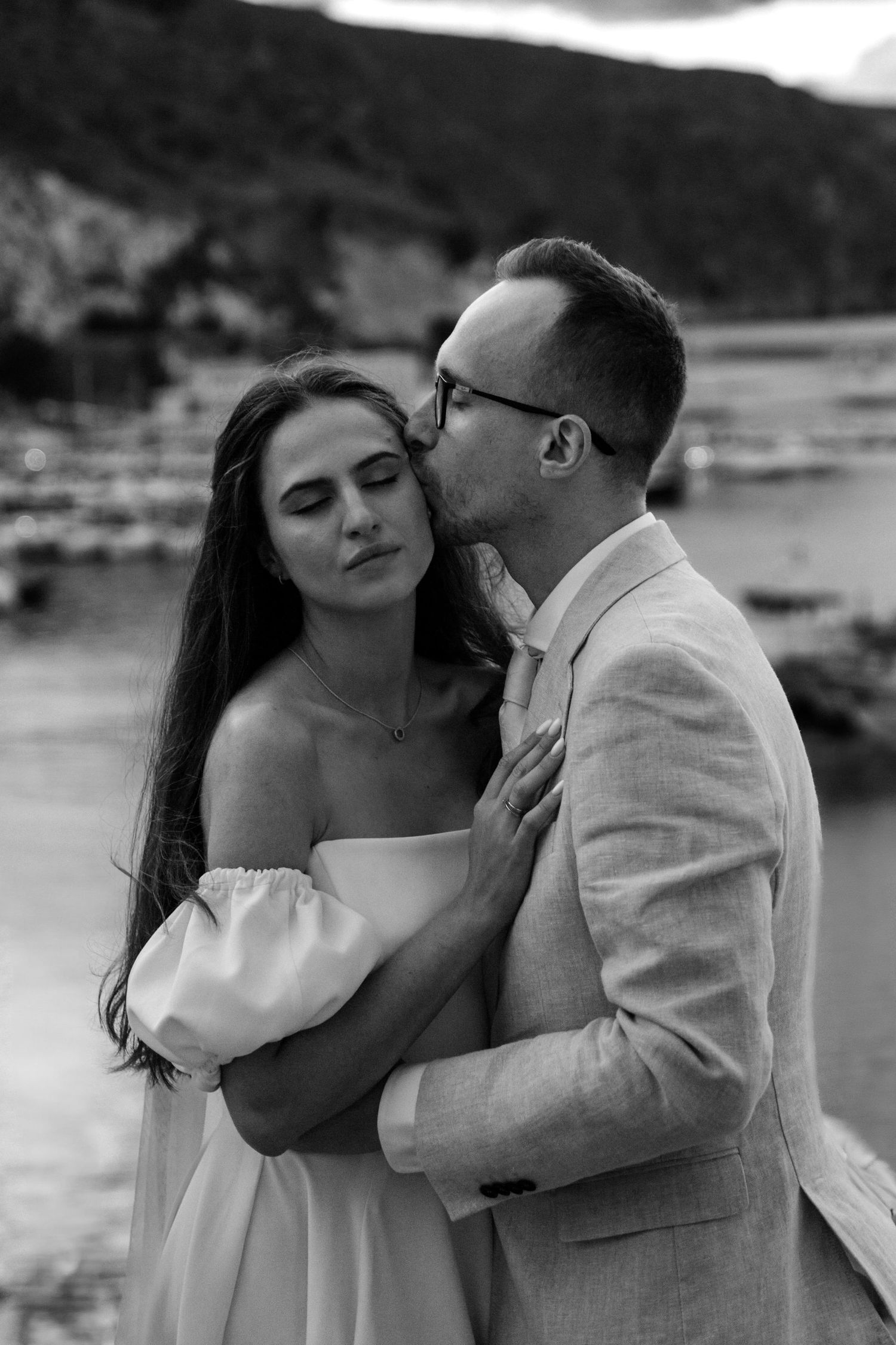 Czarno-białe romantyczne ujęcie pary młodej podczas sesji ślubnej na tle portu w Castellammare del Golfo na Sycylii.