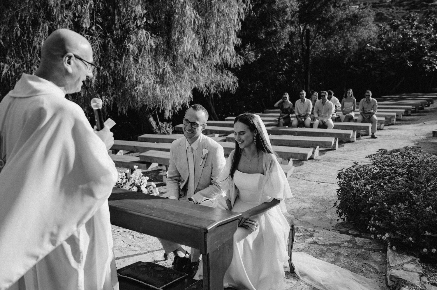 Czarno-białe zdjęcie pary młodej podczas ceremonii z widokiem na sycylijskie góry – ponadczasowy kadr ślubny
